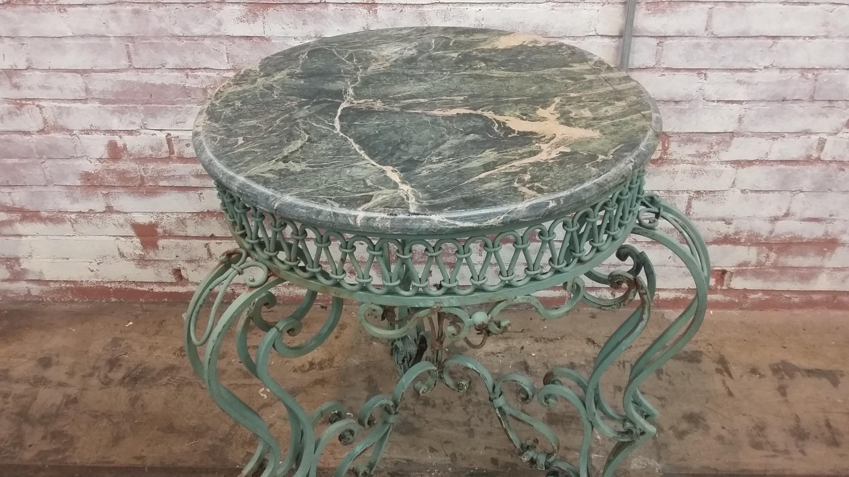 Beautiful vintage early 20th century wrought iron base with marble top. In a great verde green finish with grouping of flowers in the center of the base. Can be used inside or out. Perhaps use glass top rather than marble. Two pieces available.