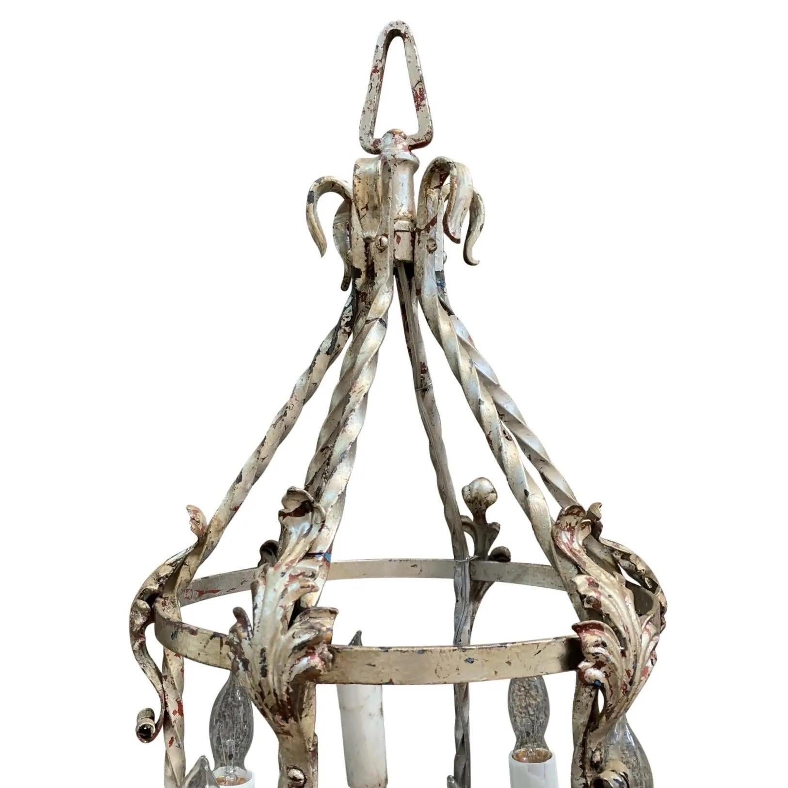 Lampadario a sei luci in ferro battuto in stile revival mediterraneo con doratura in argento. Una struttura rotonda in ferro battuto ospita sei colonne portanti leggere fissate con volute a 