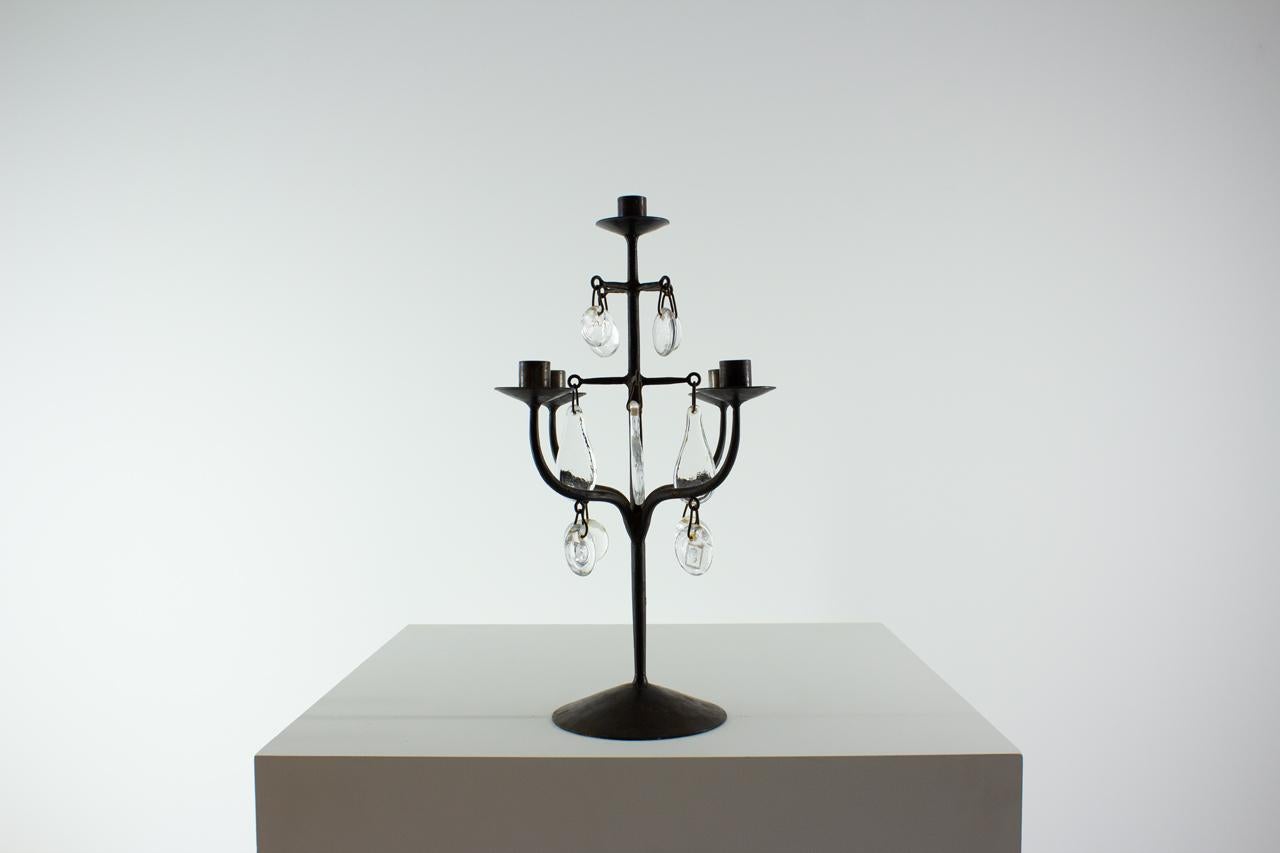 Candelabra designed by Erik Höglund during
the early 1960s. Manufactured by Boda Smide
in Sweden. Made from wrought iron and hand
made glass medallions.  Some glass pieces
with stamp of face or animal.  Good vintage
condition  with  age related 
