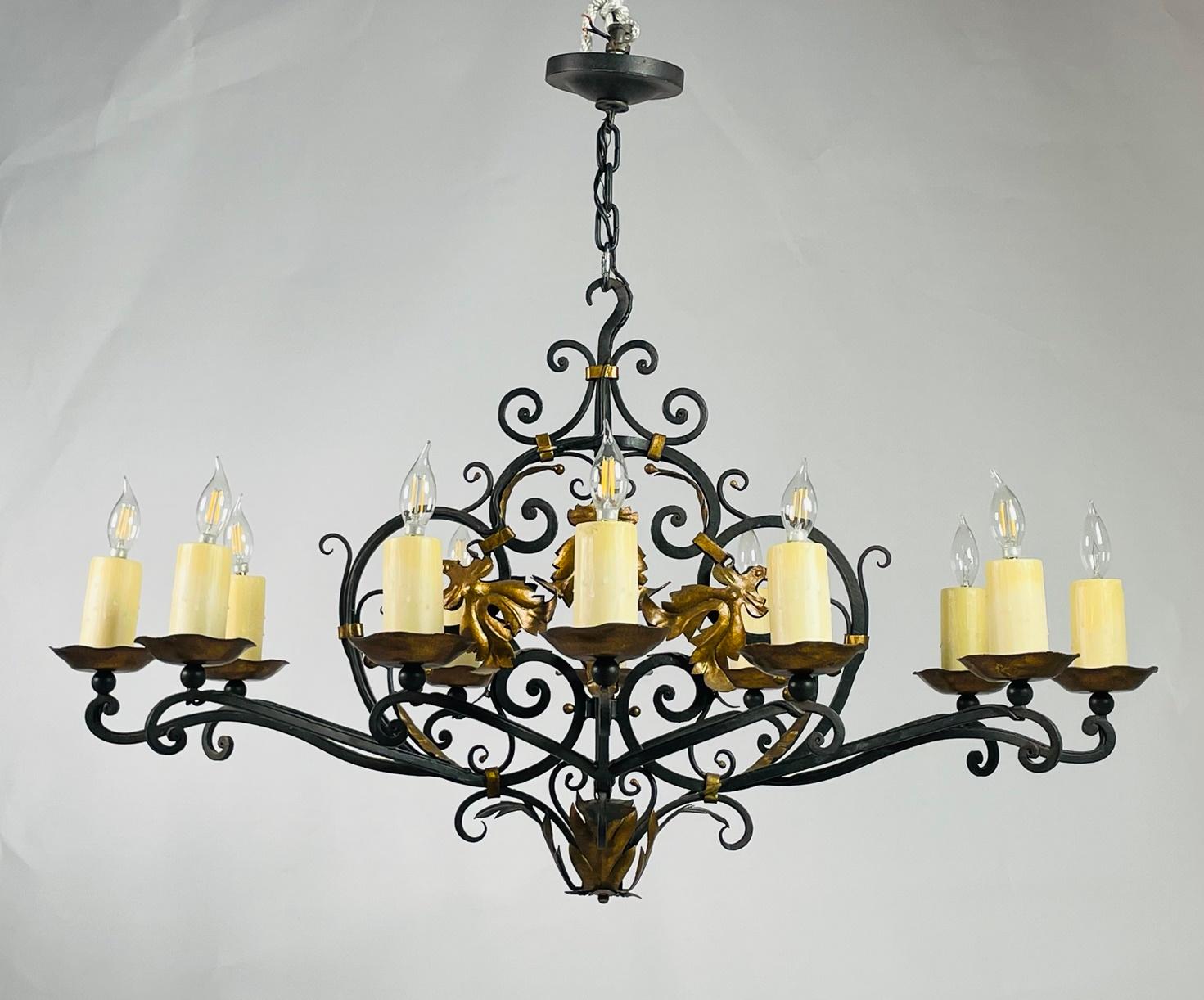 Introducing the exquisite Wrought Iron & Gold Gilt Chandelier by renowned artisan Paul Ferrante, crafted in the USA in 2016. This opulent masterpiece combines the timeless elegance of wrought iron with the luxurious allure of gold gilt, resulting in