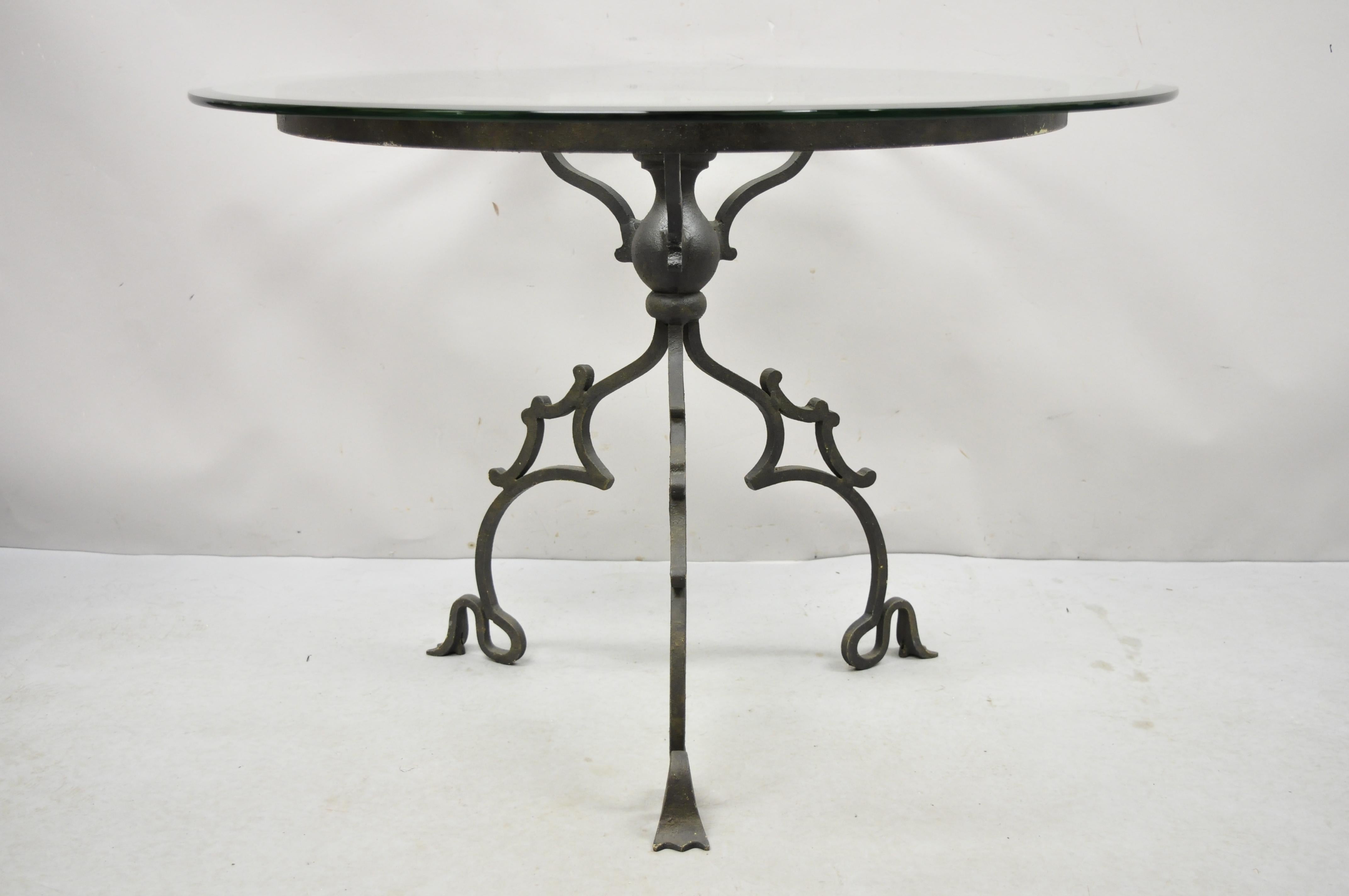 Runder Tisch mit runder Glasplatte im gotischen Stil aus Schmiedeeisen mit geschwungenem Sockel. Artikel verfügt über einen verschnörkelten schmiedeeisernen Sockel im gotischen Stil, eine runde Glasplatte, hochwertige Handwerkskunst, großartige