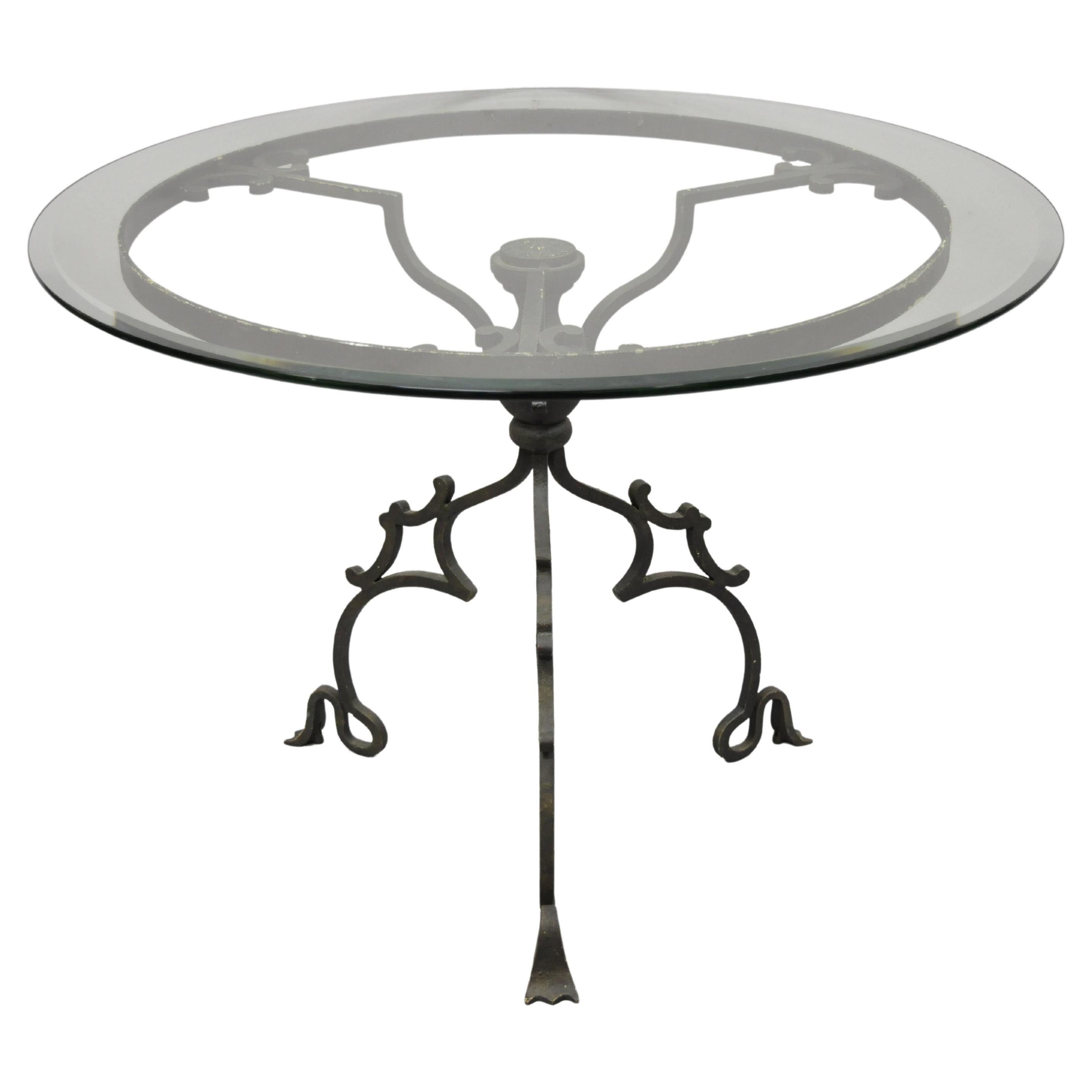 Table centrale en fer forgé de style gothique à base à volutes et plateau rond en verre