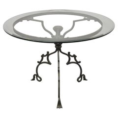 Table centrale en fer forgé de style gothique à base à volutes et plateau rond en verre