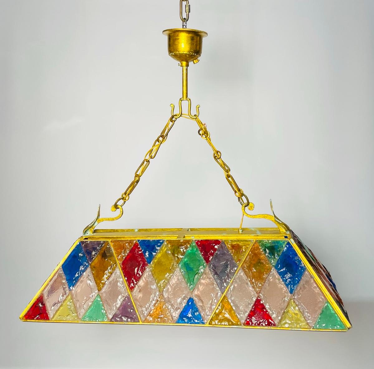 Introducing the Wrought Iron & Hammered Glass Chandelier by Longobard, a stunning piece of Italian craftsmanship from the 1970s. This exquisite chandelier is a true work of art, featuring a colorful stained glass design that will add a touch of
