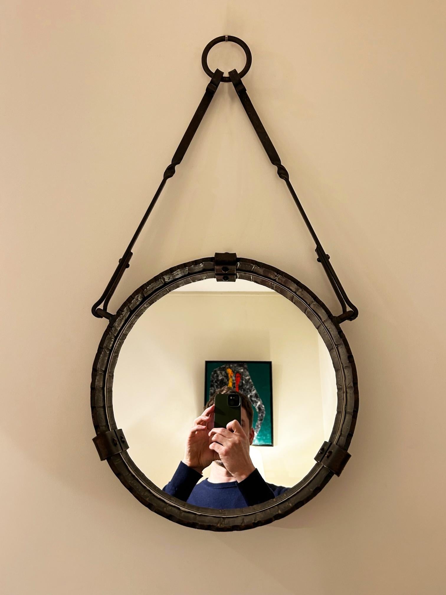 A forged iron circular hung mirror
France, Circa 1950
70 m high by 37 cm wide by 6 cm depth