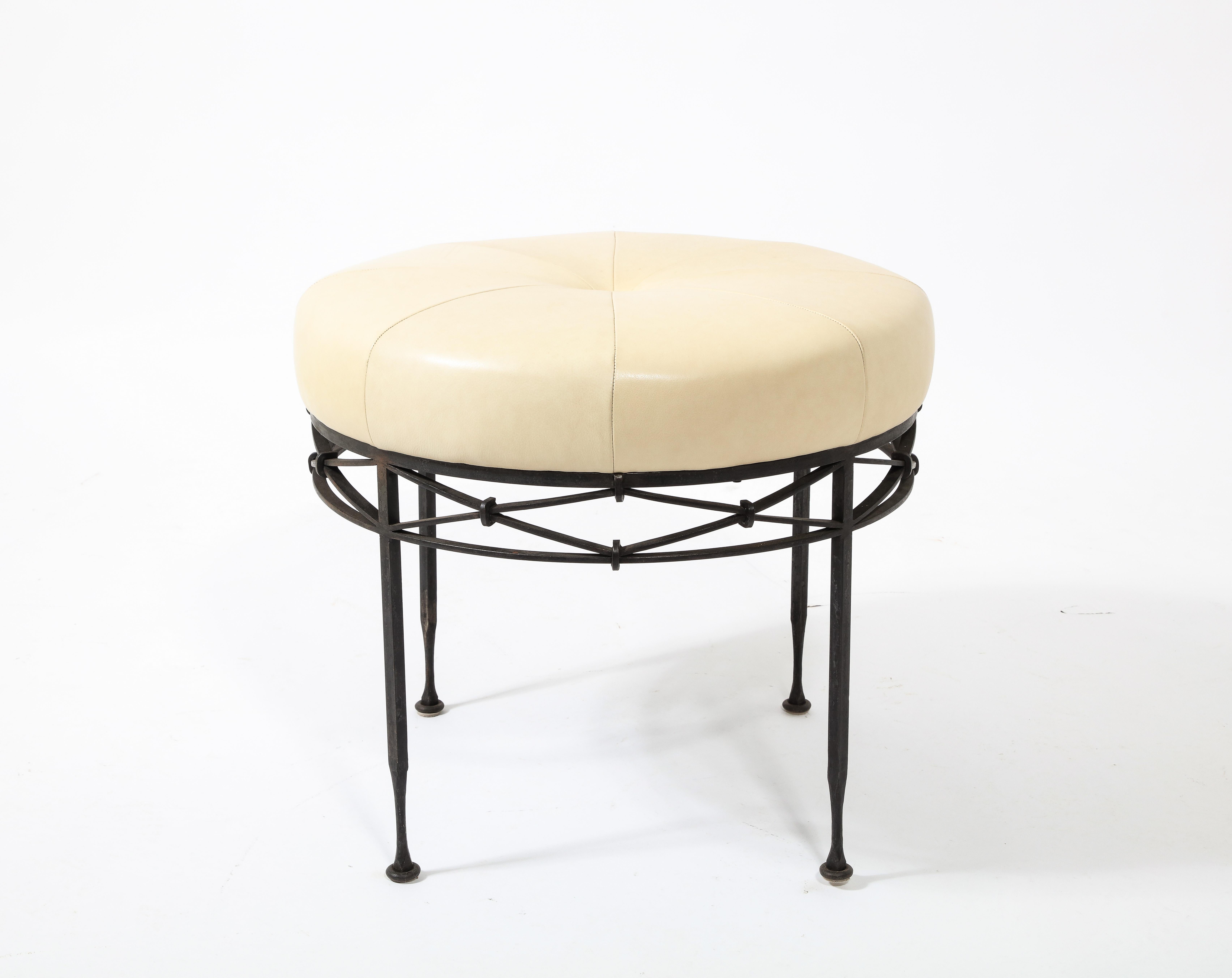 Wrought iron stool with a drum strapping design on the circumference, upholstered in leather.