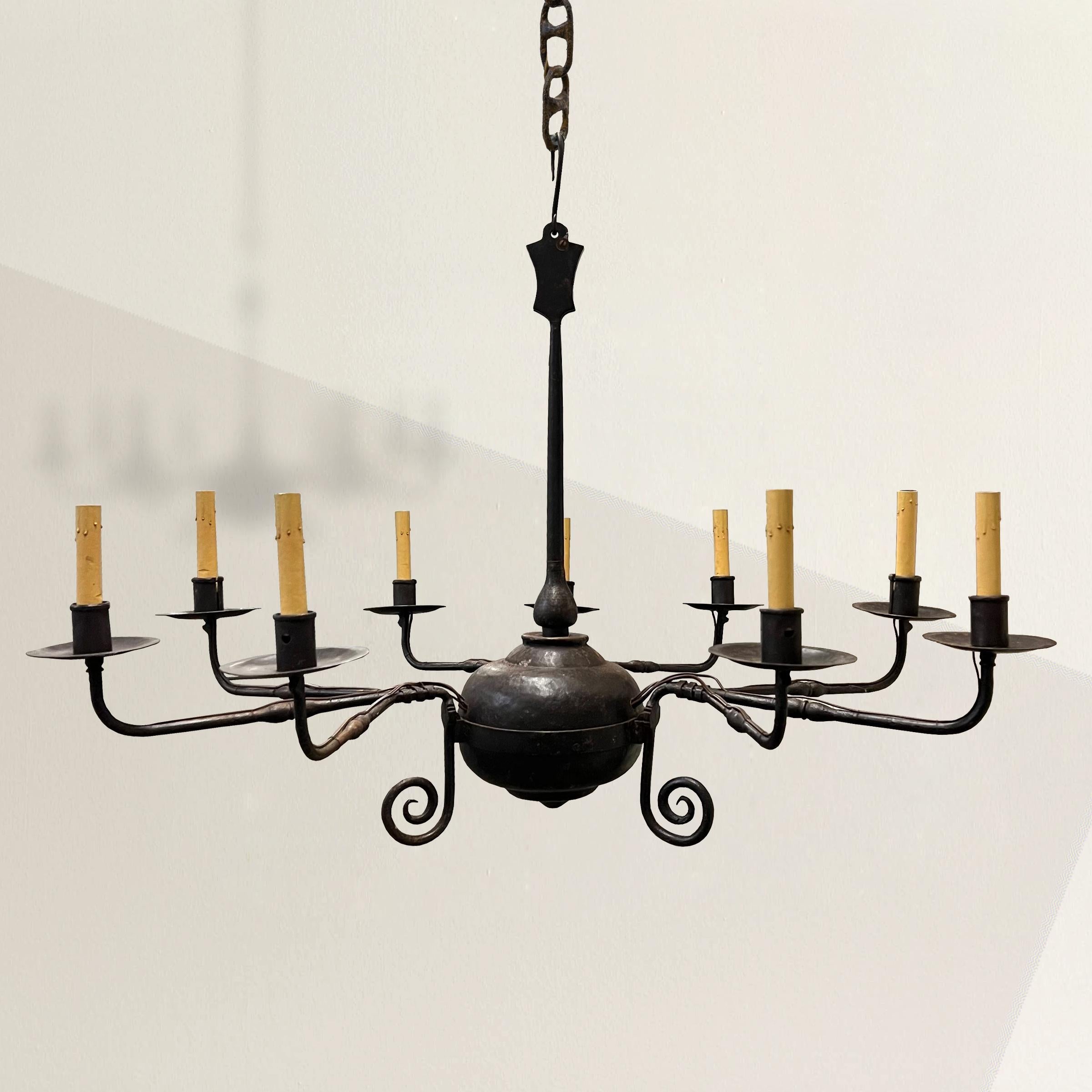 Elevate your space with the captivating charm of this 20th century American nine-arm wrought iron chandelier, boasting a simple yet chic silhouette. Crafted with precision, the clean lines and understated elegance of this chandelier make it a