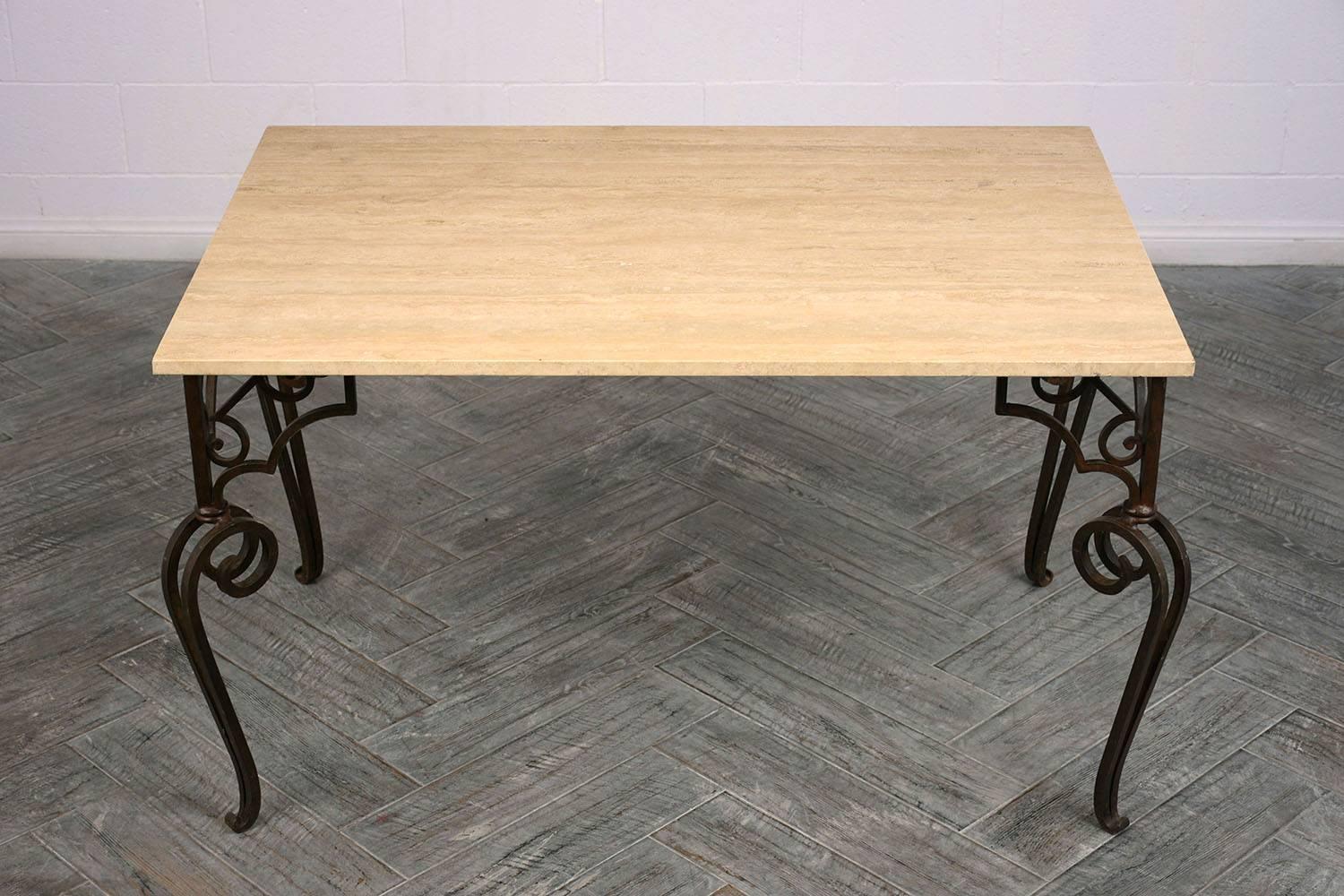 This 1970s Spanish style dining table features a wrought iron base and travertine top. The base is has scrolled legs with ornate buttress supports and a rustic finish. The travertine top is 3/4 inch thick with a rough edge. This dining table is
