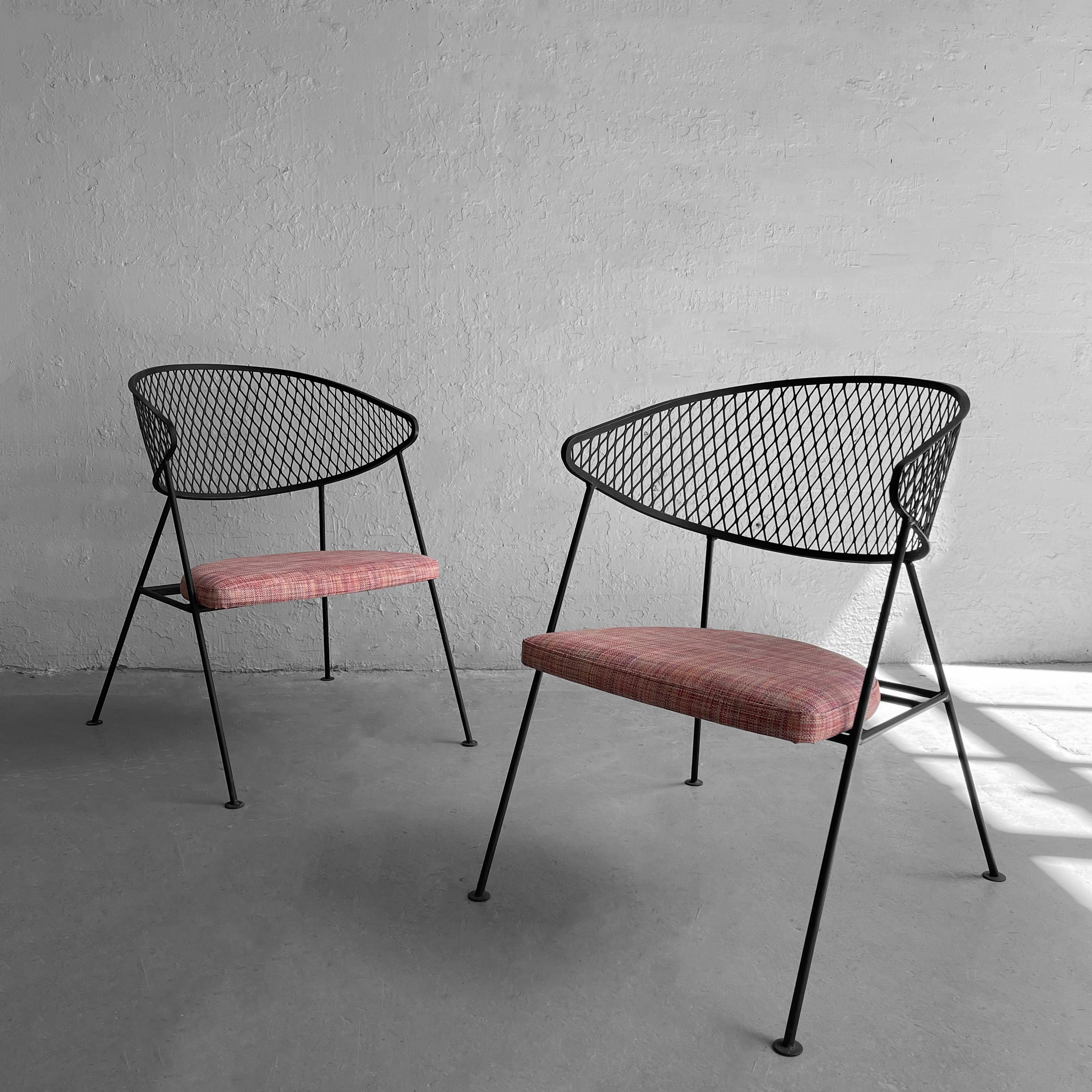 Pair of Mid-Century Modern, wrought iron, patio chairs by Maurizio Tempestini for Salterini feature mesh, demilune back rests and upholstered seats in woven raspberry outdoor vinyl.