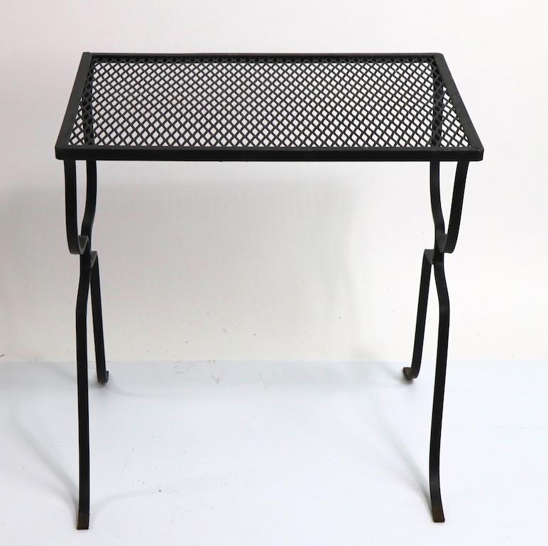 Diminutive wrought iron and metal mesh side table attributed to Woodard Furniture. Originally designed for outdoor use, also suitable for indoor application. Original, clean and ready to use condition, showing only minor cosmetic wear, normal and