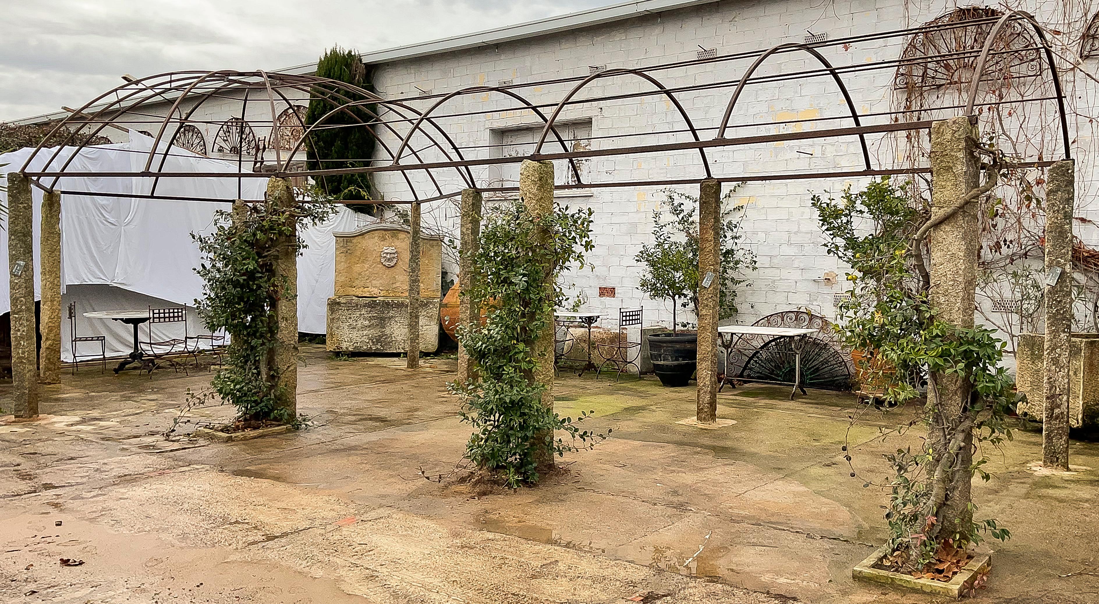 Diese große Pergola verleiht Ihrem Außenbereich einen Hauch von zeitloser Eleganz mit dieser herrlichen schmiedeeisernen Pergola und dem Schattenweg, der fest auf monolithischen Natursteinsäulen (Granit) verankert ist. Er wurde entwickelt, um