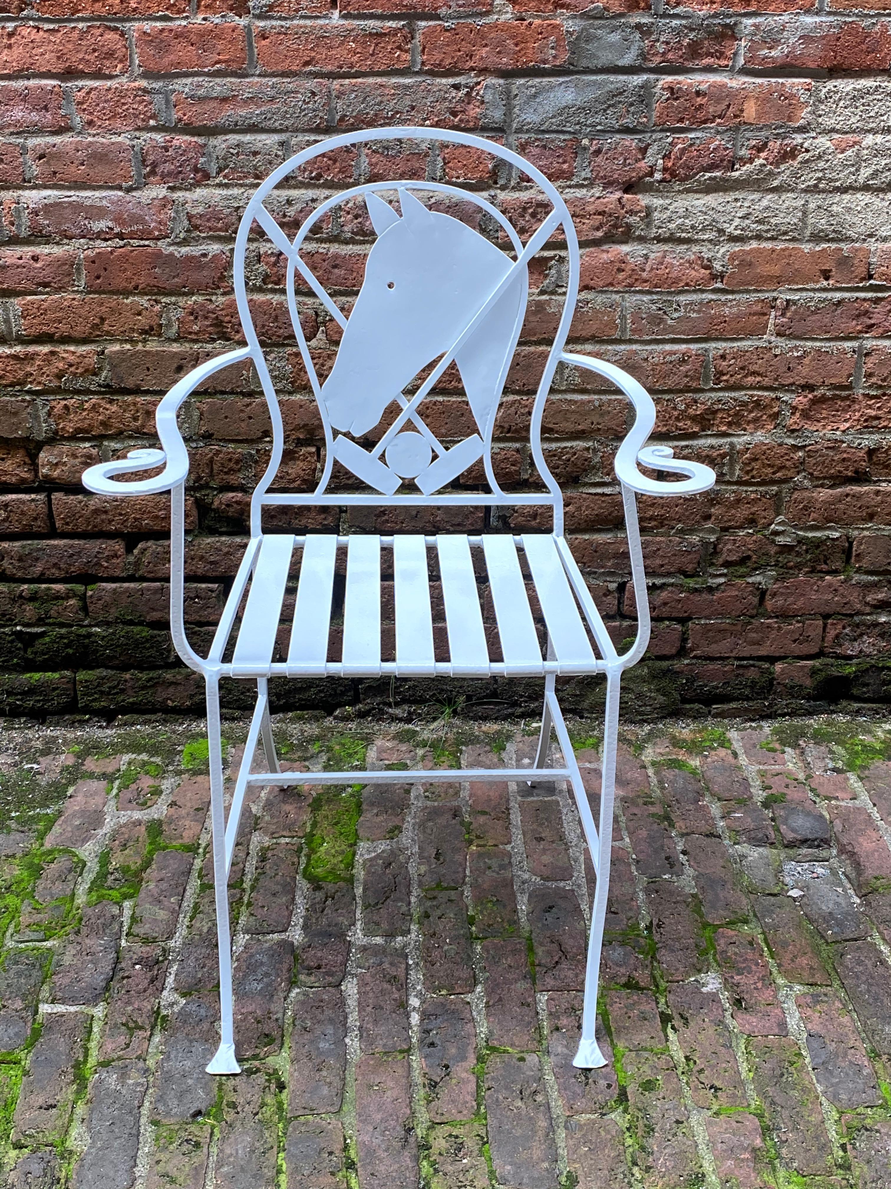 Wrought iron polo pony chair, circa 1940-1950. Sandblasted and powder-coated glossy white. Featuring a large profile horse head with crossed polo mallets, arms ending in a stylized horse shoe curve, strap seat, spade type foot, and 'H' stretcher