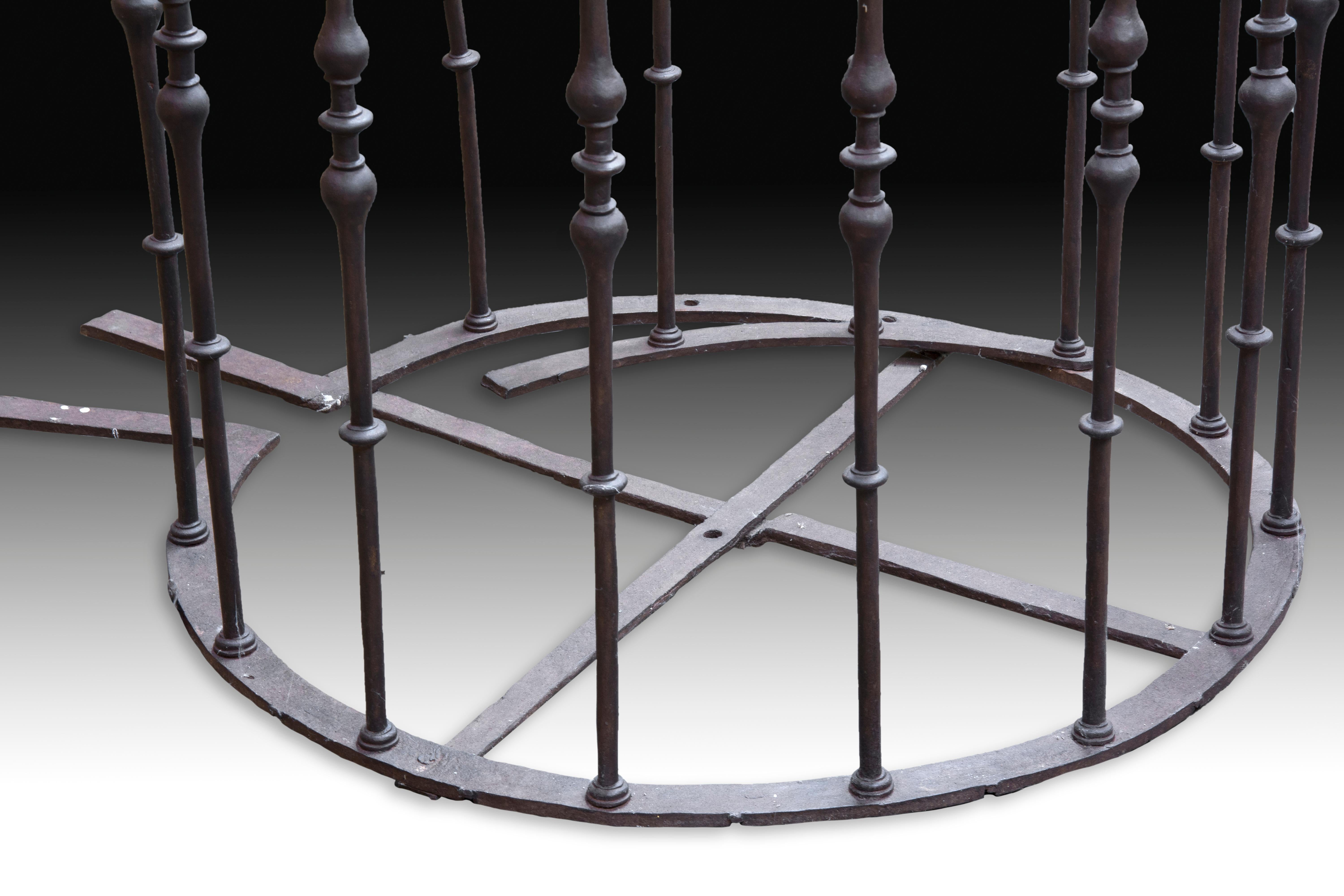 Wrought iron grating with thirteen bars with double pear and discs in their shafts, arranged in a circle with bars of the same flat material (circular and cross combined at the base for a firmer grip, and arranged in a circle at the top), that would