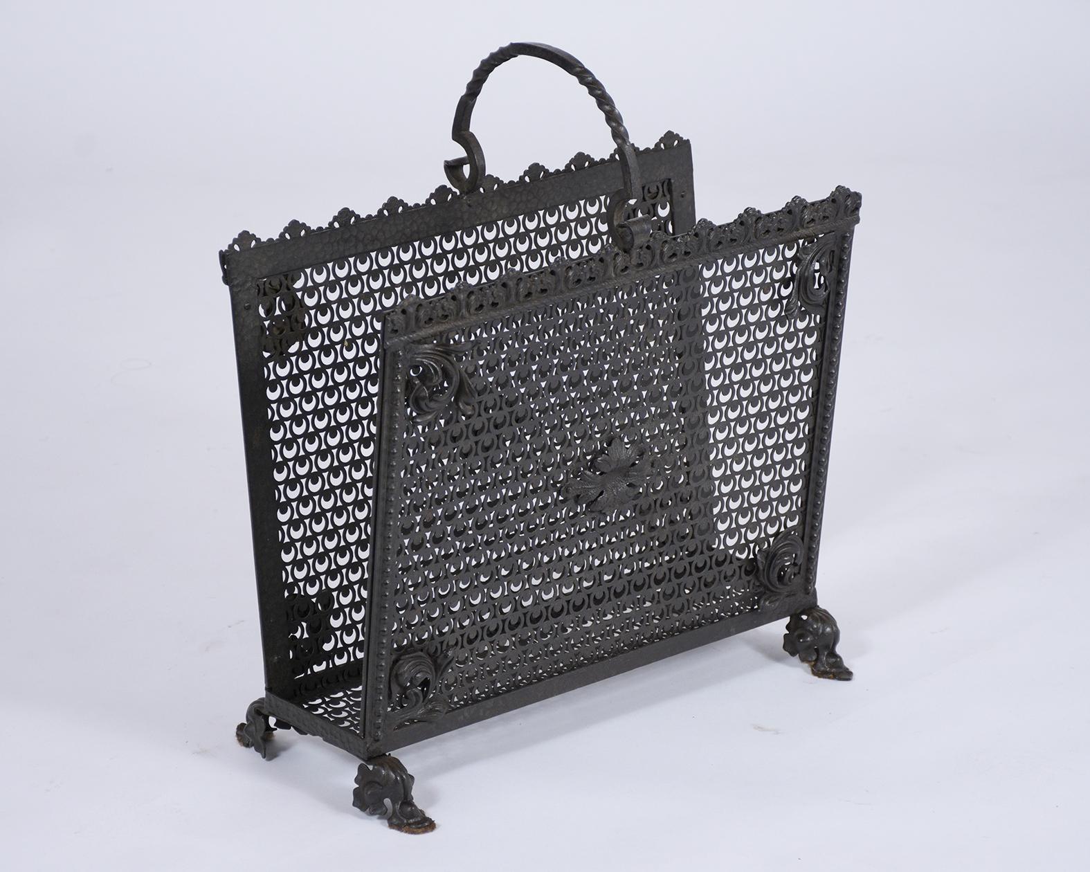 An antique wrought iron rack magazine made out of iron, this unique piece features a beautiful design forge crafted details and has been painted in black color with a beautiful patina finish.