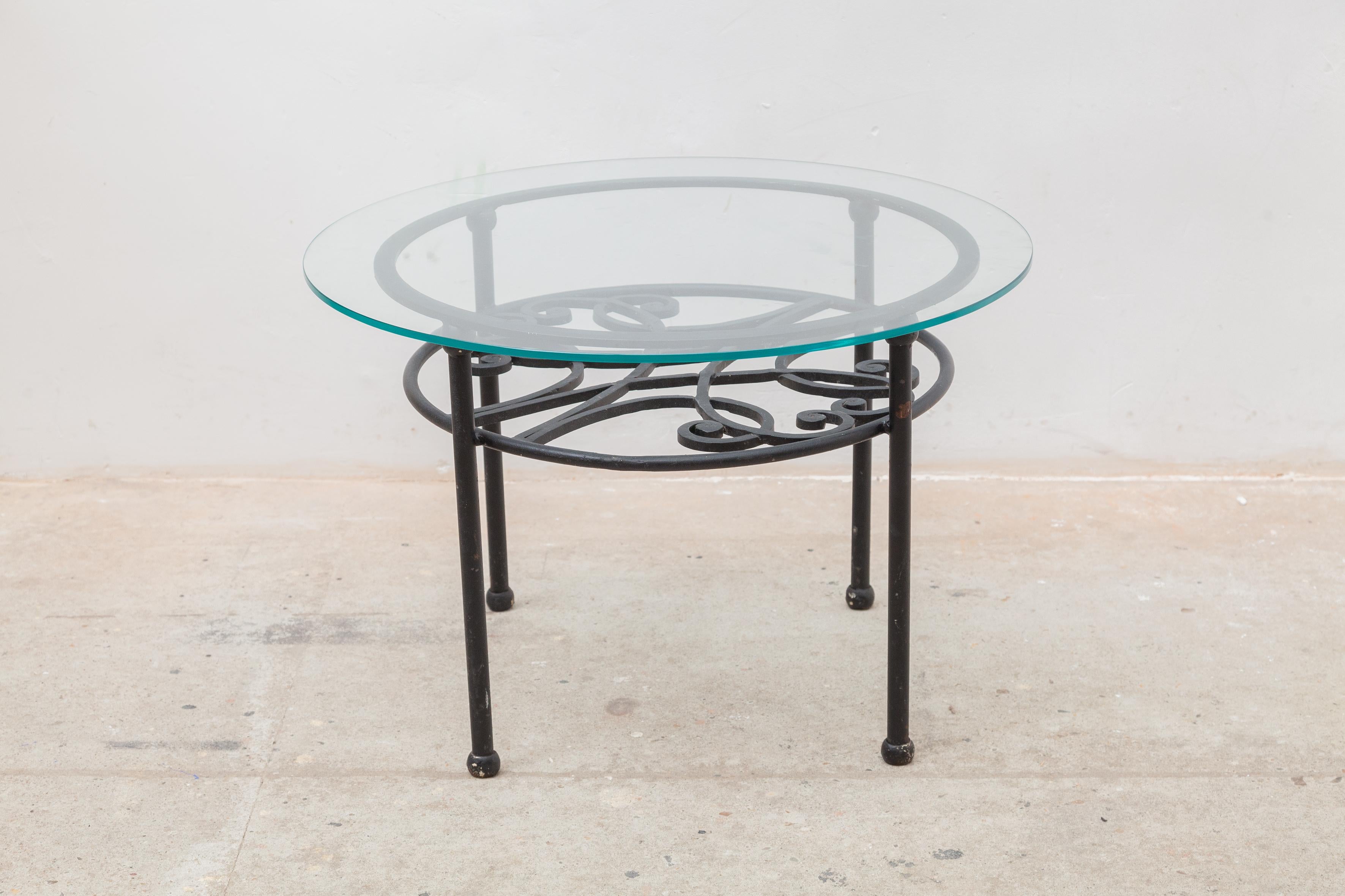 Beautiful wrought iron coffee table with a glass top. It is in fabulous condition. The iron base has its original finish, which with age and use has gained a marvelous patina. It would make a wonderful center table or console in an entry or living