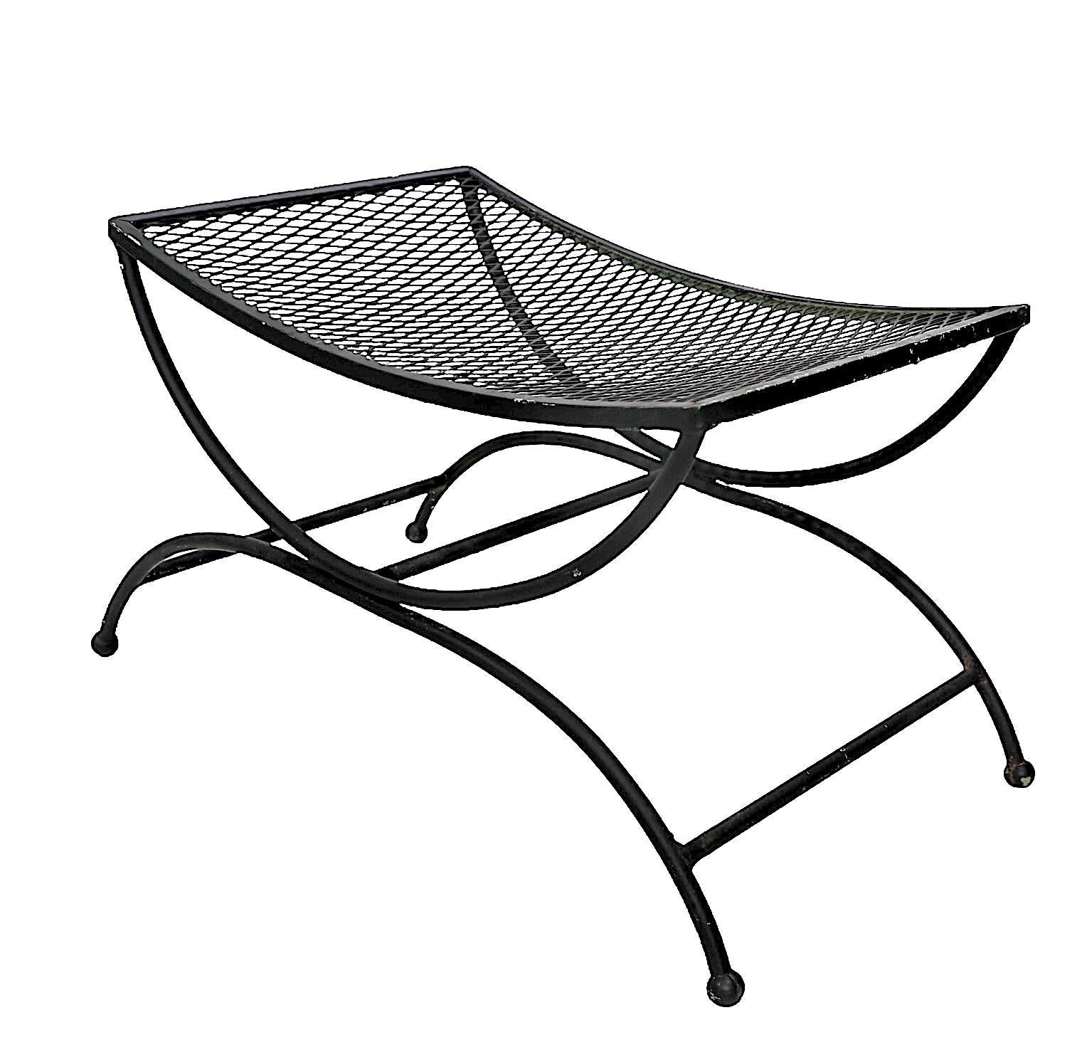 Unusual saddle seat form bench, stool, ottoman by Woodard. Constructed of tubular metal with a curved metal mesh seat rest - Suitable for both indoor and outdoor use. This chic bench is in good original condition, structurally sound and sturdy, 