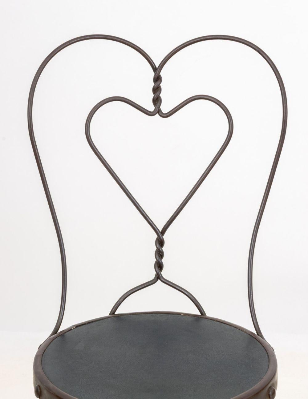 Ensemble de quatre chaises d'appoint en fer forgé, deux avec dossier en forme de coeur, chacune avec assise en bois. Plus haut : 35