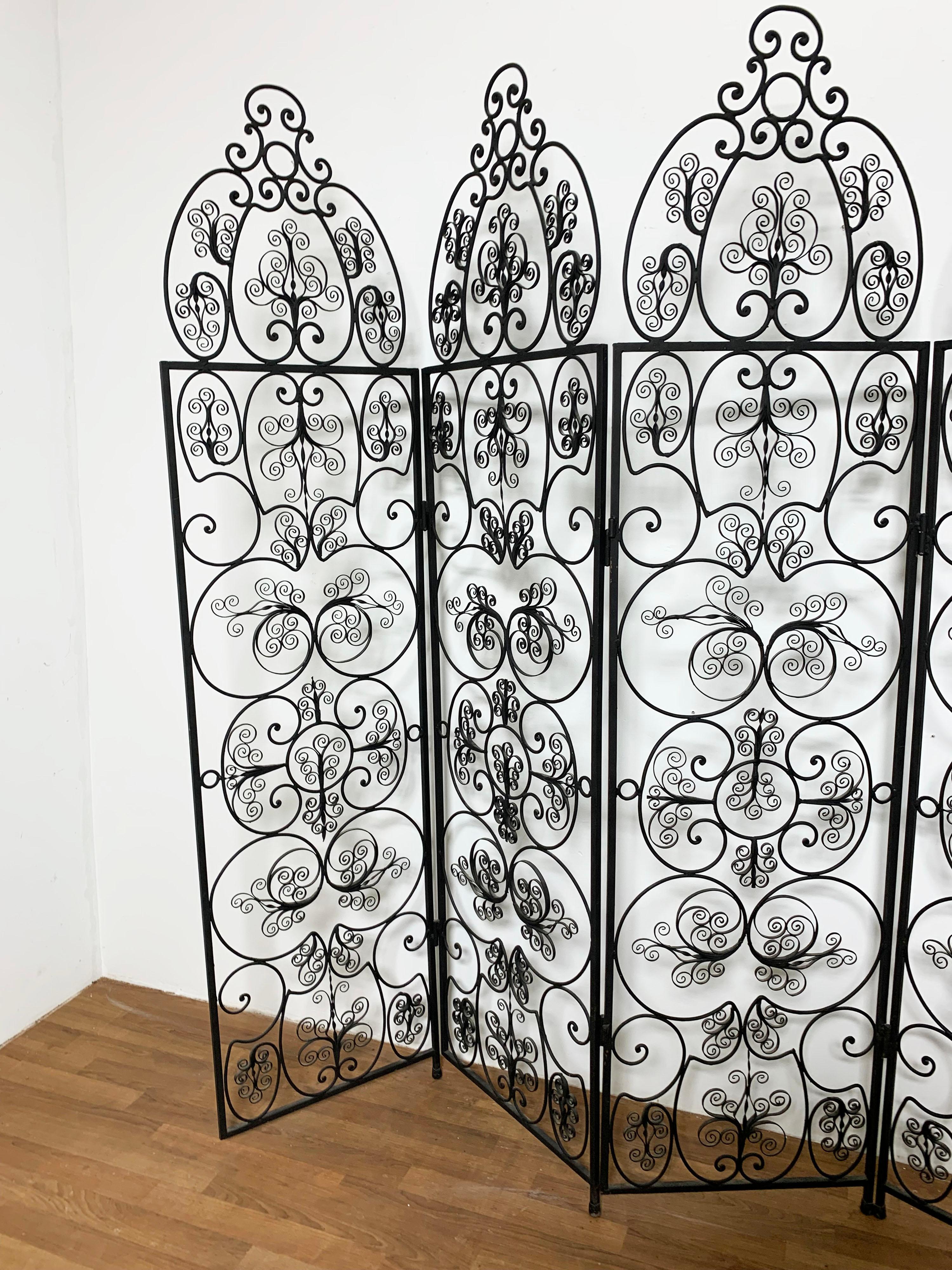 A Spanish six panel wrought iron screen of fine decorative scrollwork, ca. 1950s.

Each panel measures 74
