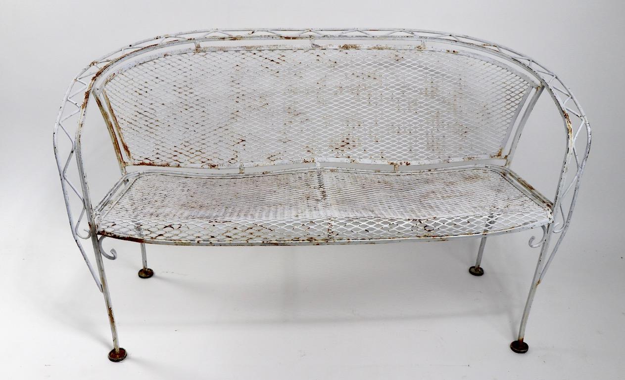 Nice decorative loveseat in wrought iron and metal mesh, attributed to Salterini. This example is in very good, original condition, free of breaks, bends, or repairs, the finish shows wear normal and consistent with age and use. We offer custom