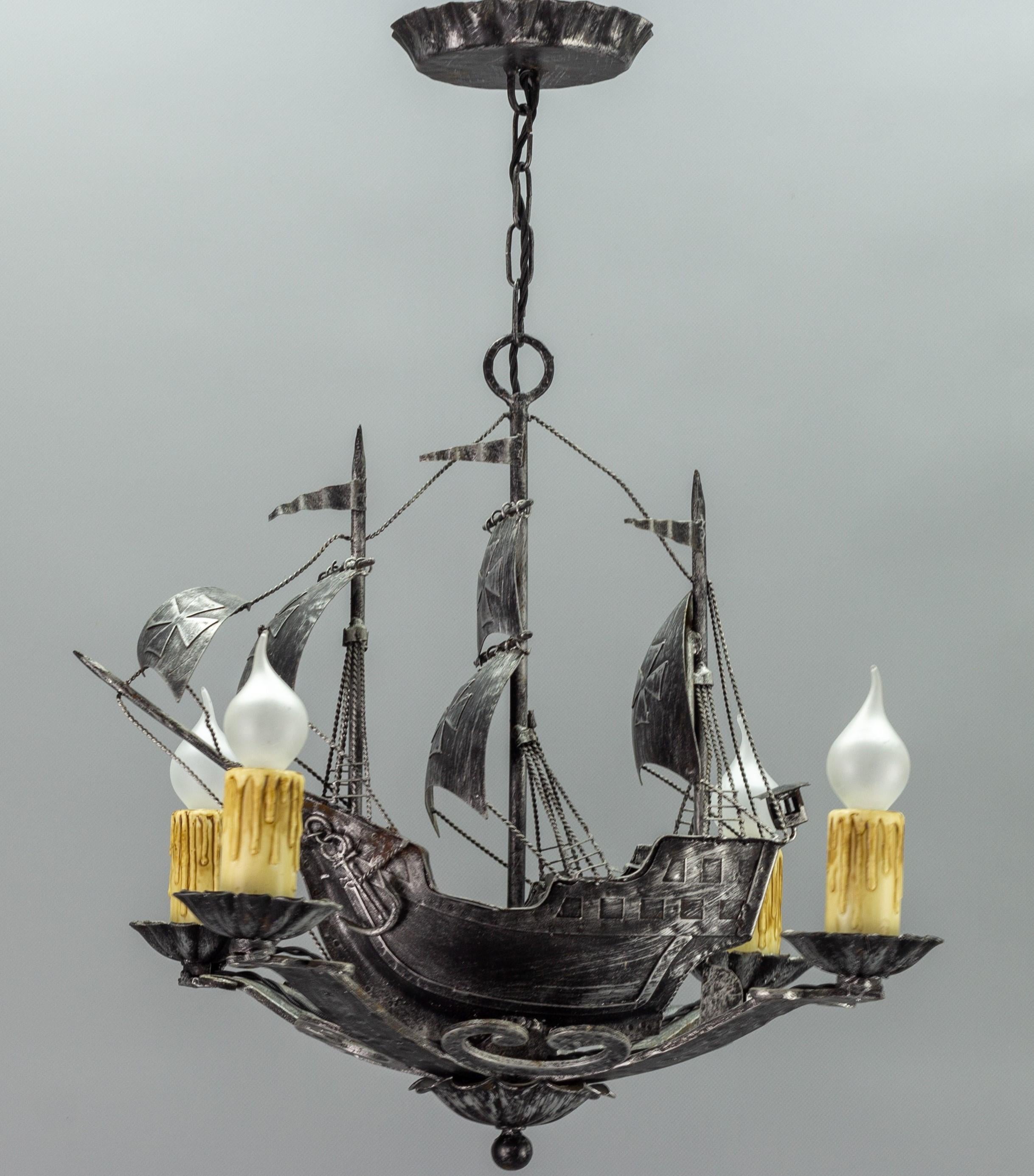 Impressive silver color wrought iron four-light chandelier represents a beautiful Spanish galleon with three masts and sailing ship details such as sails, ropes, anchor, flags, and lantern. 
This outstanding chandelier is a real eye-catcher and