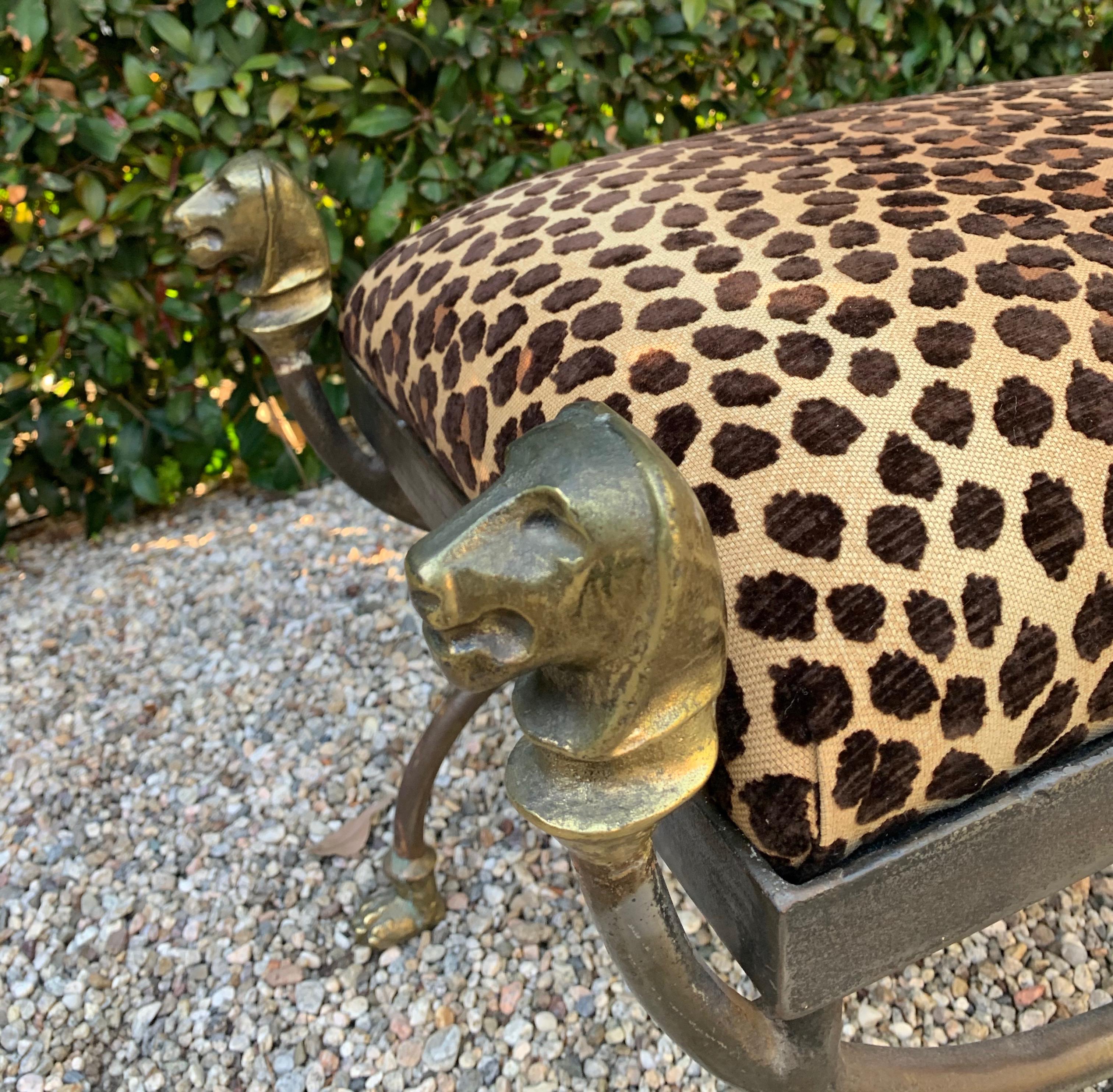 A wrought iron stool with cast Bronze lion head, paws and Medallions. The shape and detailing are exceptional. A fabulous statement in newly upholstered cut velvet leopard, suiting any room, foot of the bed to library and guest room.

Seat is very
