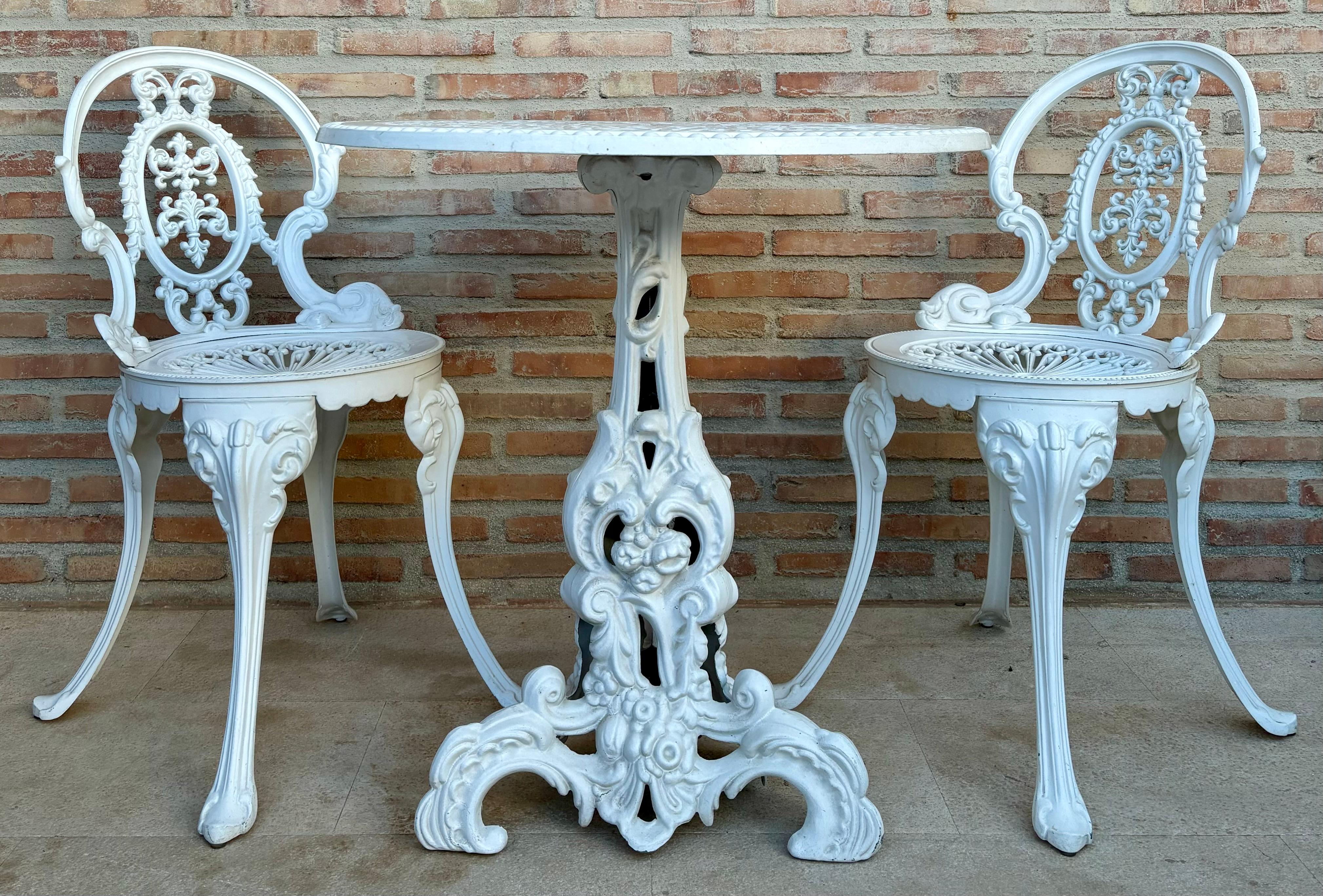 Ensemble patio/salle à manger trois pièces en fer forgé. Une table avec un plateau en fer sculpté et deux chaises. Peint en blanc.


La table mesure : 65,5 cm de largeur x 68 cm de hauteur. Les chaises mesurent : 77 cm de hauteur x 49 cm de largeur