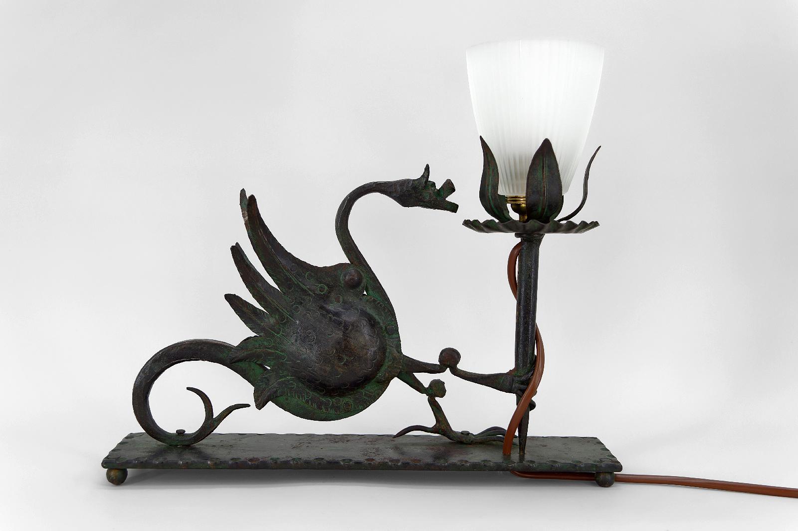 Elegante Tisch-/Schreibtischlampe aus Schmiedeeisen, die einen geflügelten Drachen darstellt, der eine Fackel/Taschenlampe hält. 

Schöne Metallarbeit: Thema gut gemacht, schöne Grünspan-Patina.

Neogotik/Gotik-Revival/Jugendstil, Italien, um