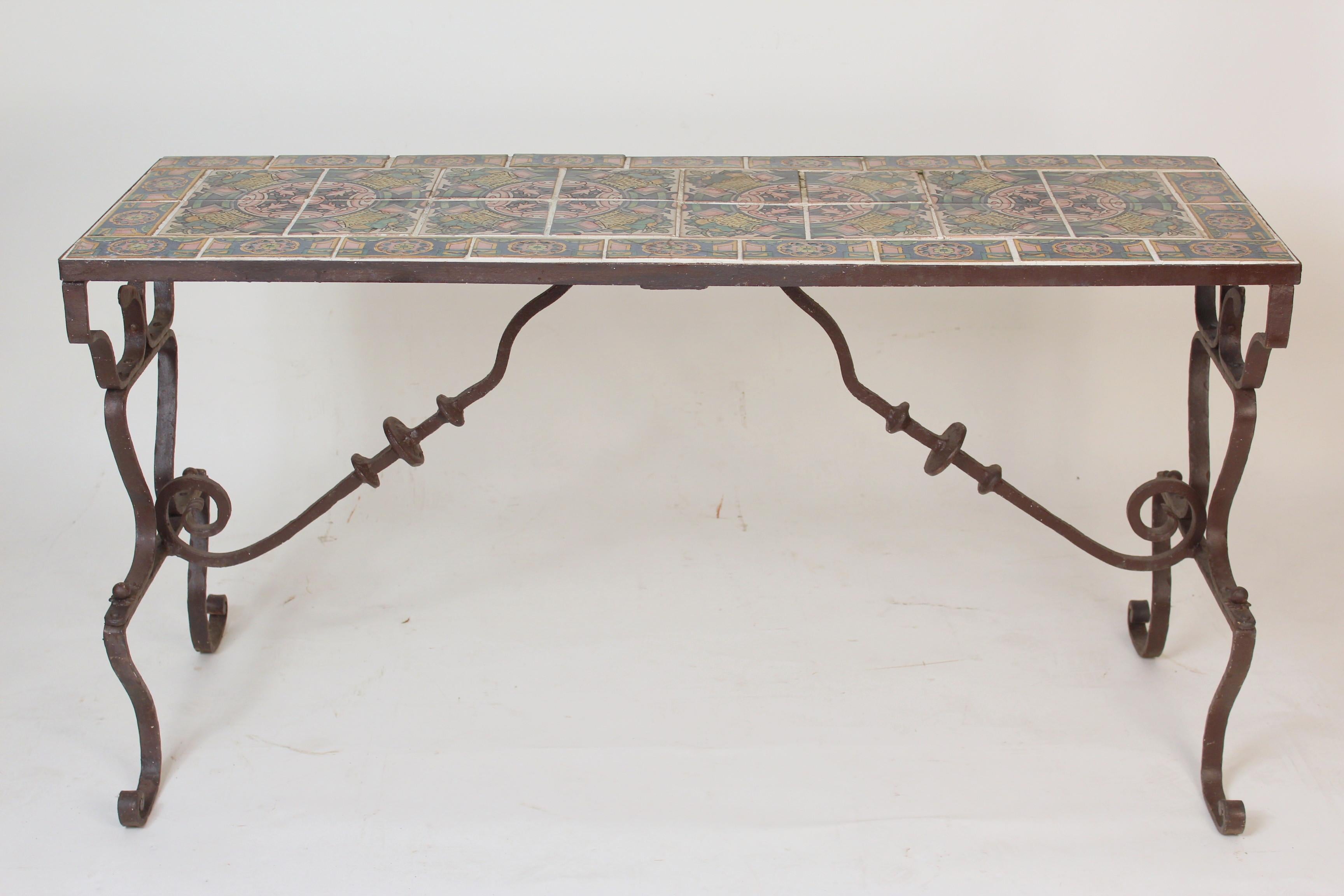 Wrought iron table base with Spanish tiles on the top, circa 1950. The base is wrought iron, with a thin layer of gesso to hold the paint.