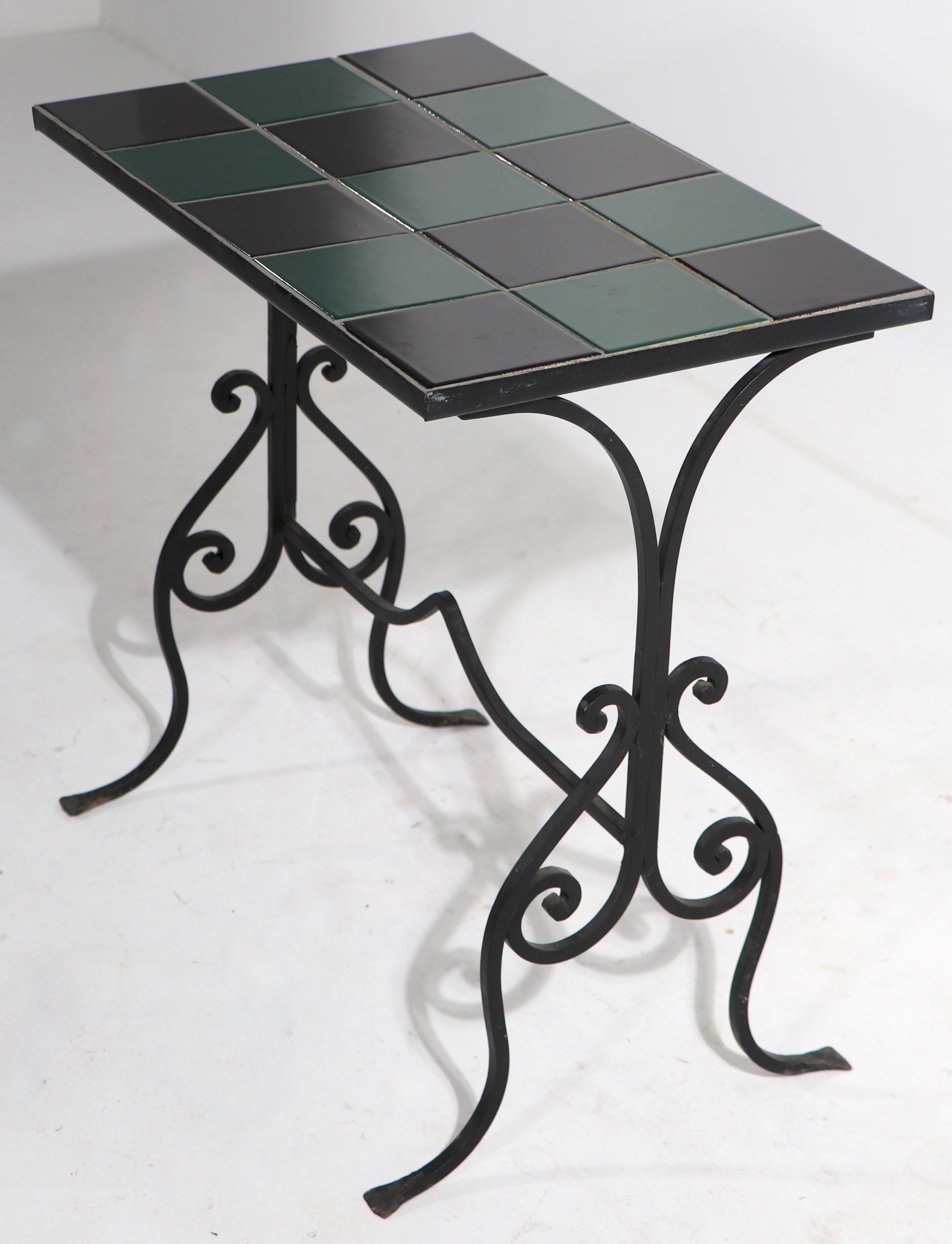Nice graphic checkerboard top tile top table on decorative wrought iron base. This example is in very fine, original condition, clean and ready to use.