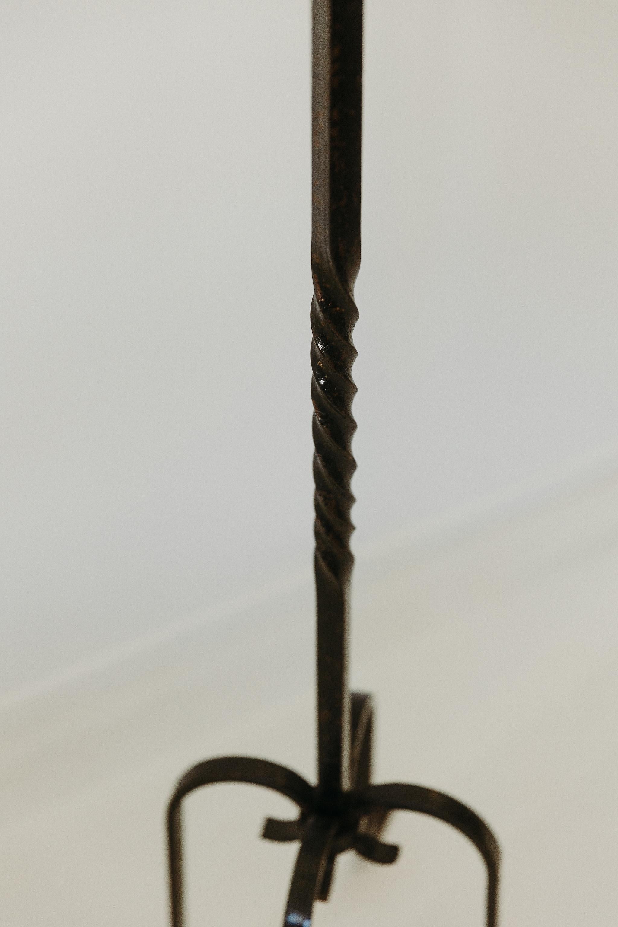 
Cet élégant candélabre à deux branches en fer forgé allie la grâce ornementale à la rigueur artisanale. Sa tige haute et mince s'élève à partir d'un trépied, tandis que des bras fluides et courbés s'étendent vers l'extérieur pour accueillir deux