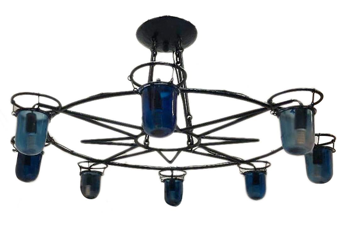 Luminaire italien à huit lumières en fer forgé avec des inserts en verre bleu, vers les années 1930.

Mesures :
Diamètre 38