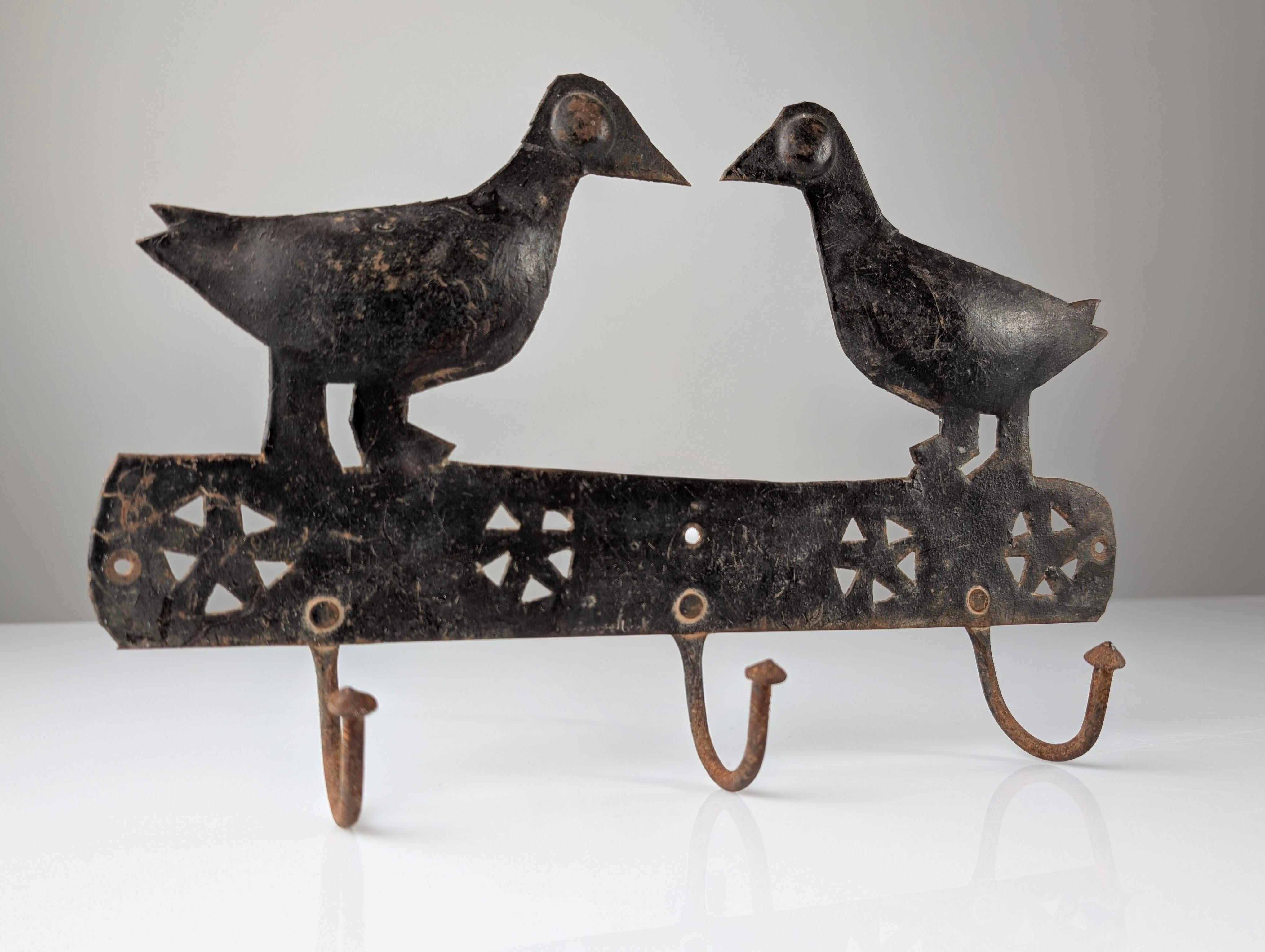 Charming wall-mounted wrought iron coat rack attributed to Atelier Marolles, the renowned French artistic workshop founded in the 1950s by Jean Touret. Featuring a design of two birds in its characteristic simplistic and symbolic style, it reflects