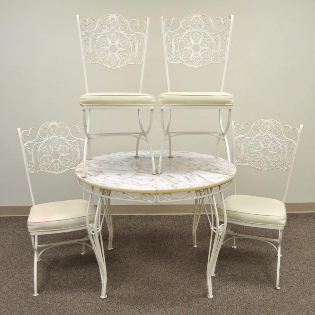 Vintage five-piece wrought iron sun room dining set from the Andalusian line by Woodard. Item features set of four curule form scrolling dining chairs, round extension dining table, laminate top (NO LEAVES), circa mid-20th century, USA.
