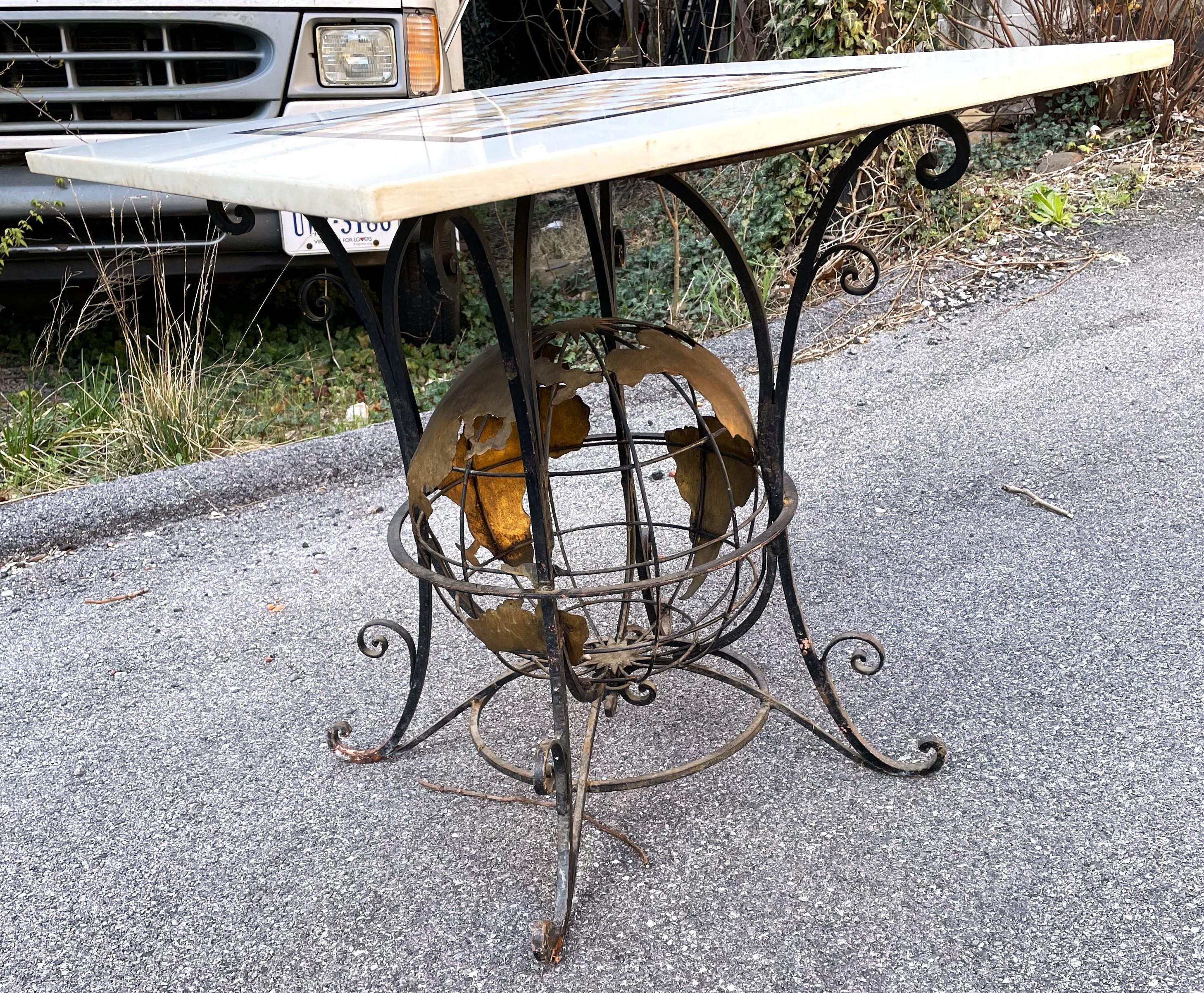 What a fabulous Iron based game table with a world globe in the center of the base. The metal work is fantastic with heavy gage iron and flattened, gold painted pieces forming the continents. The top is a 30 inch by 30 inch square of white marble