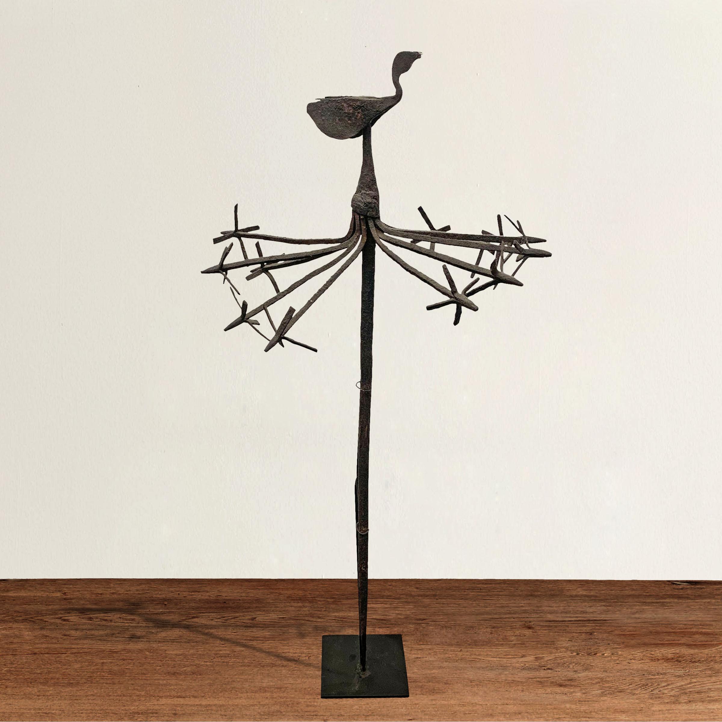 A fantastic early 20th century wrought iron Yoruba ?`sanyìn staff with a large bird in the center, said to represent the ?`sanyìn himself, surrounded by several abstract stylized birds. 
The ?`sanyìn is the deity of plants and herbal medicine and