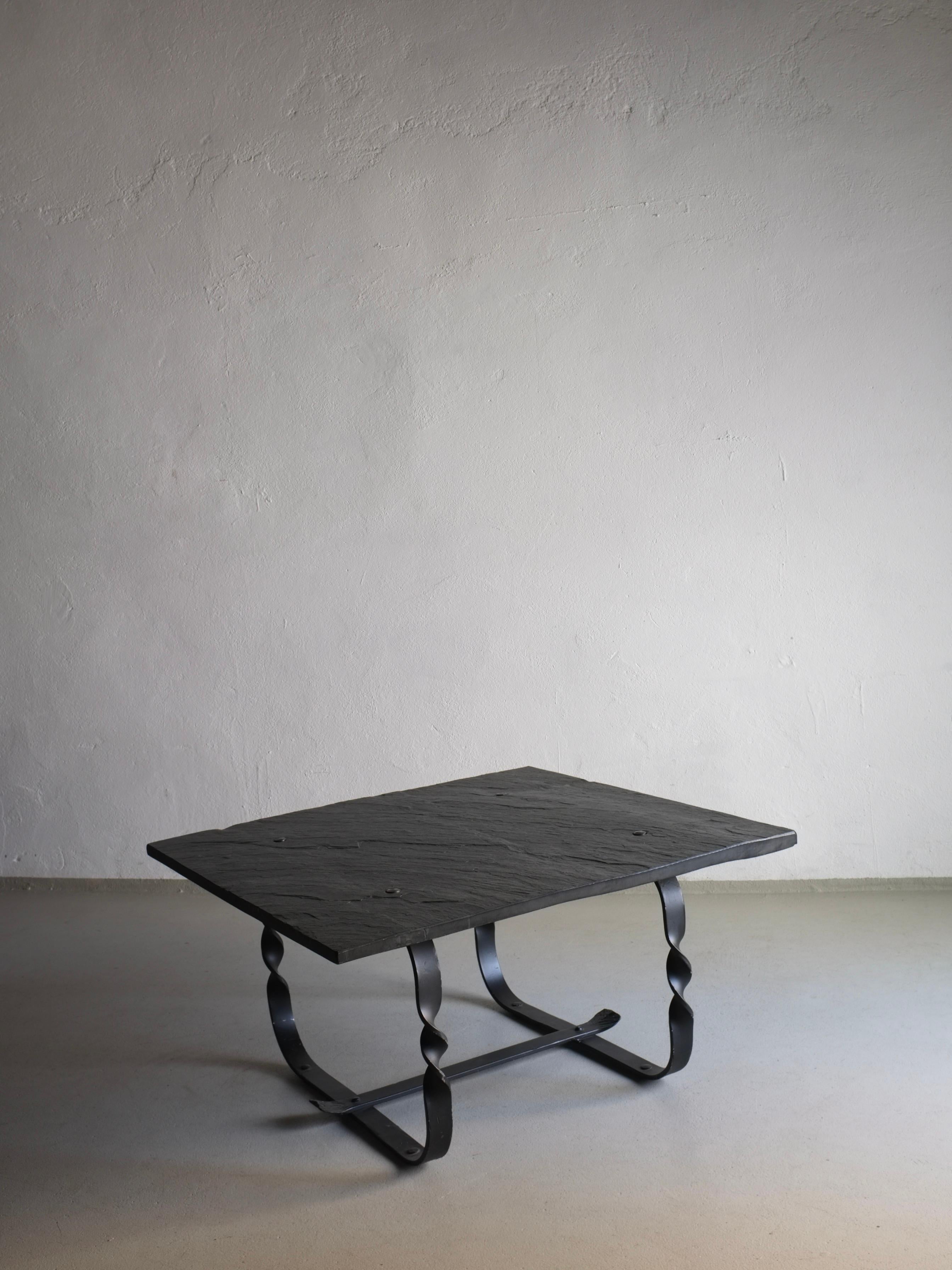 Schwarze Tischplatte aus Wabi Sabi-Stein mit geschmiedetem Metallgestell. Ein gewichtiger Gegenstand.