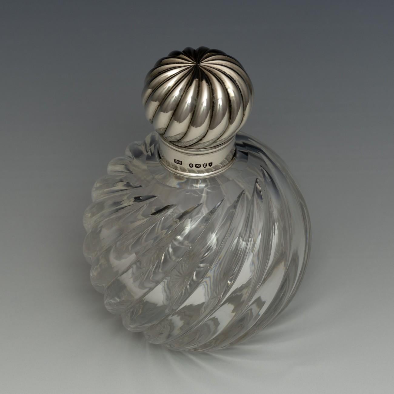 A fabulous scent bottle with star cut base, glass stopper, silver collar and silver top that matches the decorative finish of the wrythen glass, hallmarked London 1886. Also has makers mark for Sampson Mordan & Co. Wrythen glass is created by