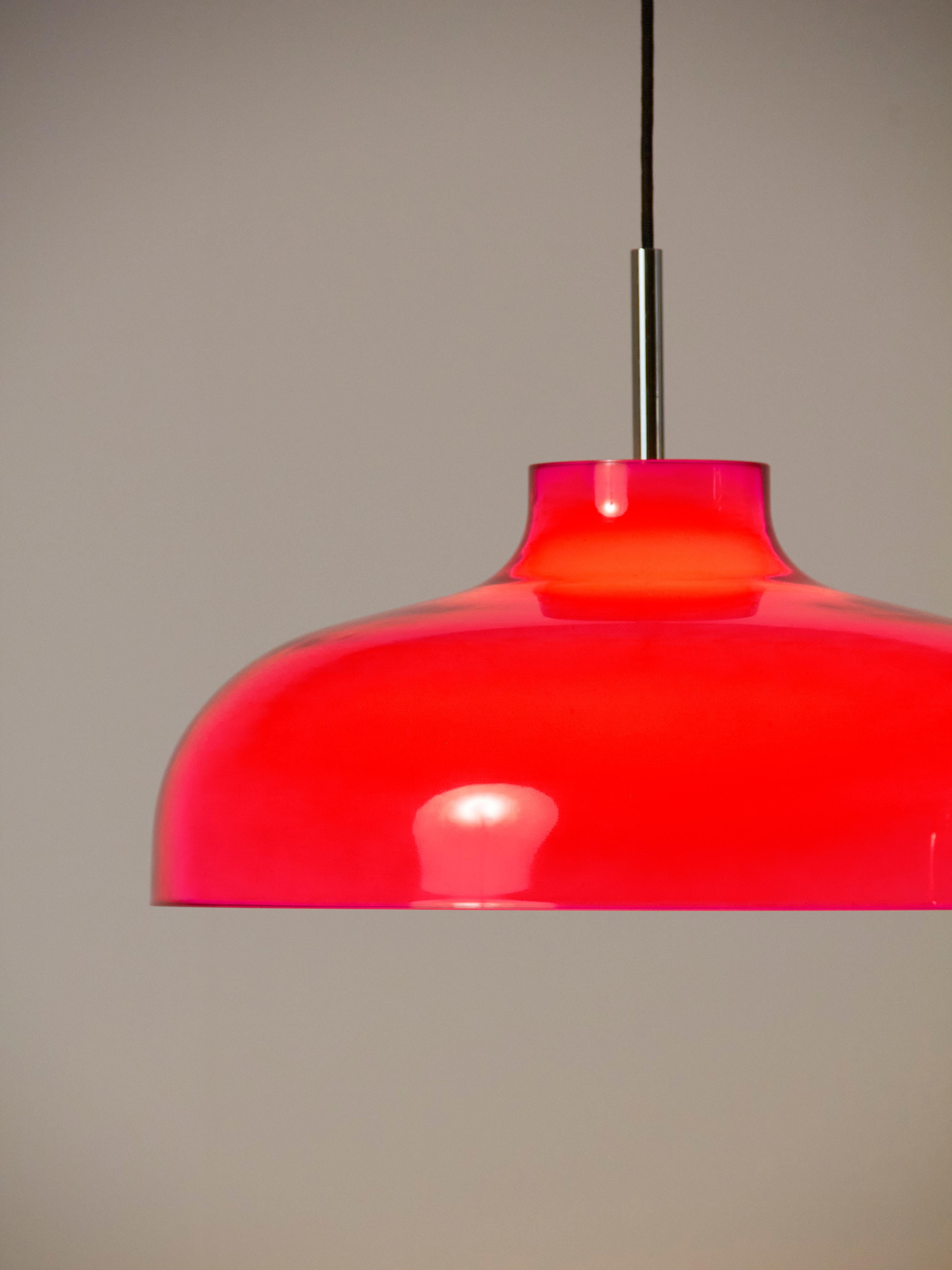 Lampada a sospensione disegnata nel 1962 da Miguel Milá e prodotta dall'azienda Polinax.

Si caratterizza per il suo ampio ed esclusivo paralume bicolore dalle curve sinuose realizzato in metacrilato iniettato, rosso ciliegia all'esterno e bianco