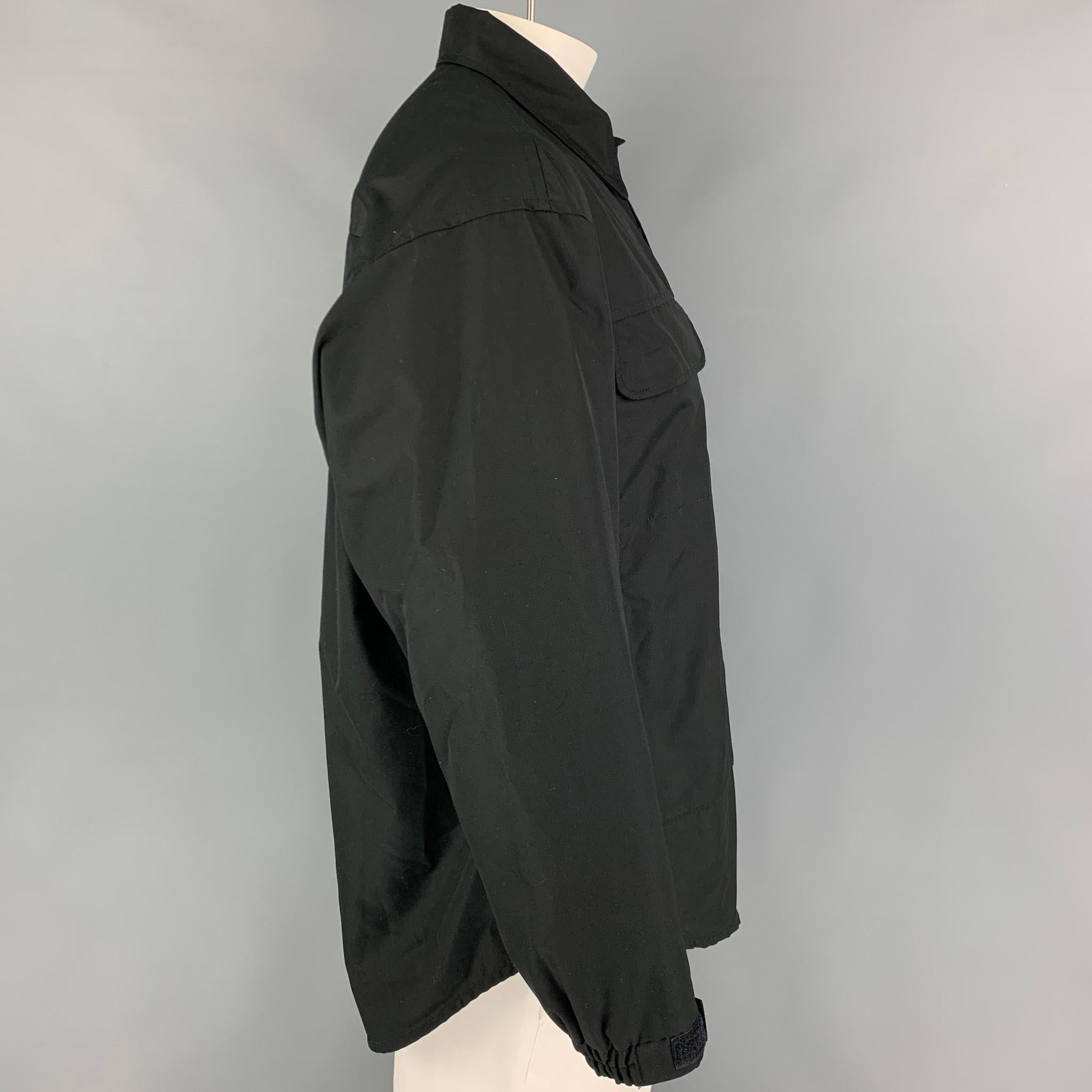 WTAPS jacket comes in a black polyester with a mesh liner featuring a spread collar, front pockets, and a hidden placket closure. Made in Japan. 

Excellent Pre-Owned Condition.
Marked: X2 02

Measurements:

Shoulder: 22 in.
Chest: 52 in.
Sleeve: 22