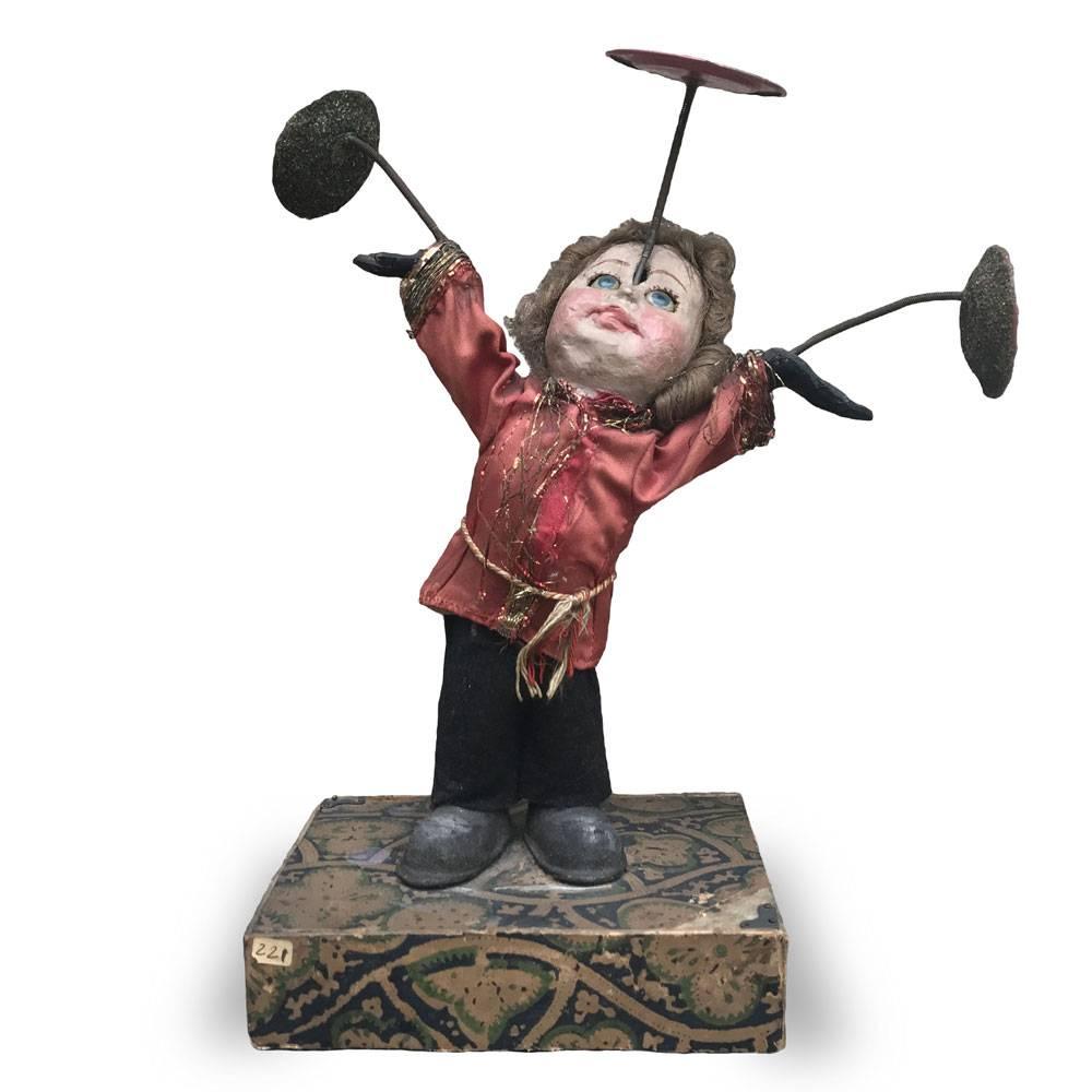 Early 20th century juggling clown realized in Germany with painted paper-mache, standing on a paper lined base, equipped with a mechanism, to impress a fun movement.
Turning the key on the back, the clown performs a balance game by spinning three