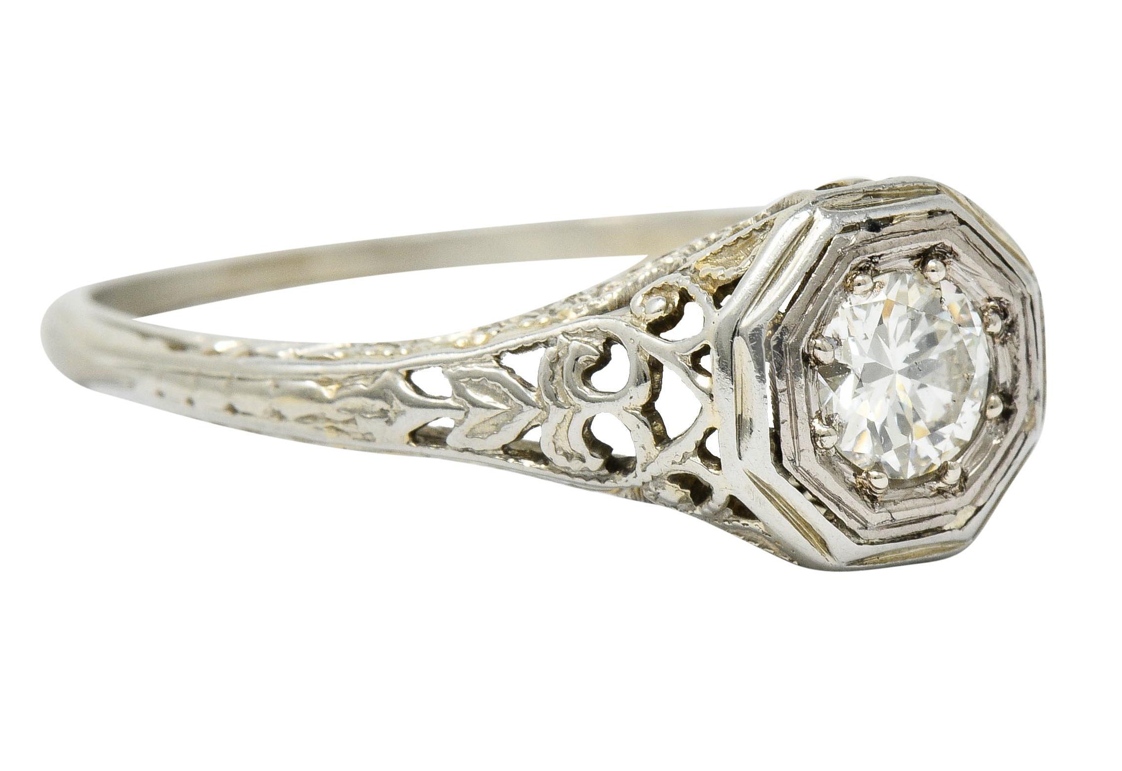 Centering a transitional cut diamond weighing approximately 0.25 carat; K color with SI clarity

Set low in an octagonal head in a decorous filigree mounting

With engraved details and an arrow motif at shoulders

Maker's mark for W.W. Fulmer & Co.