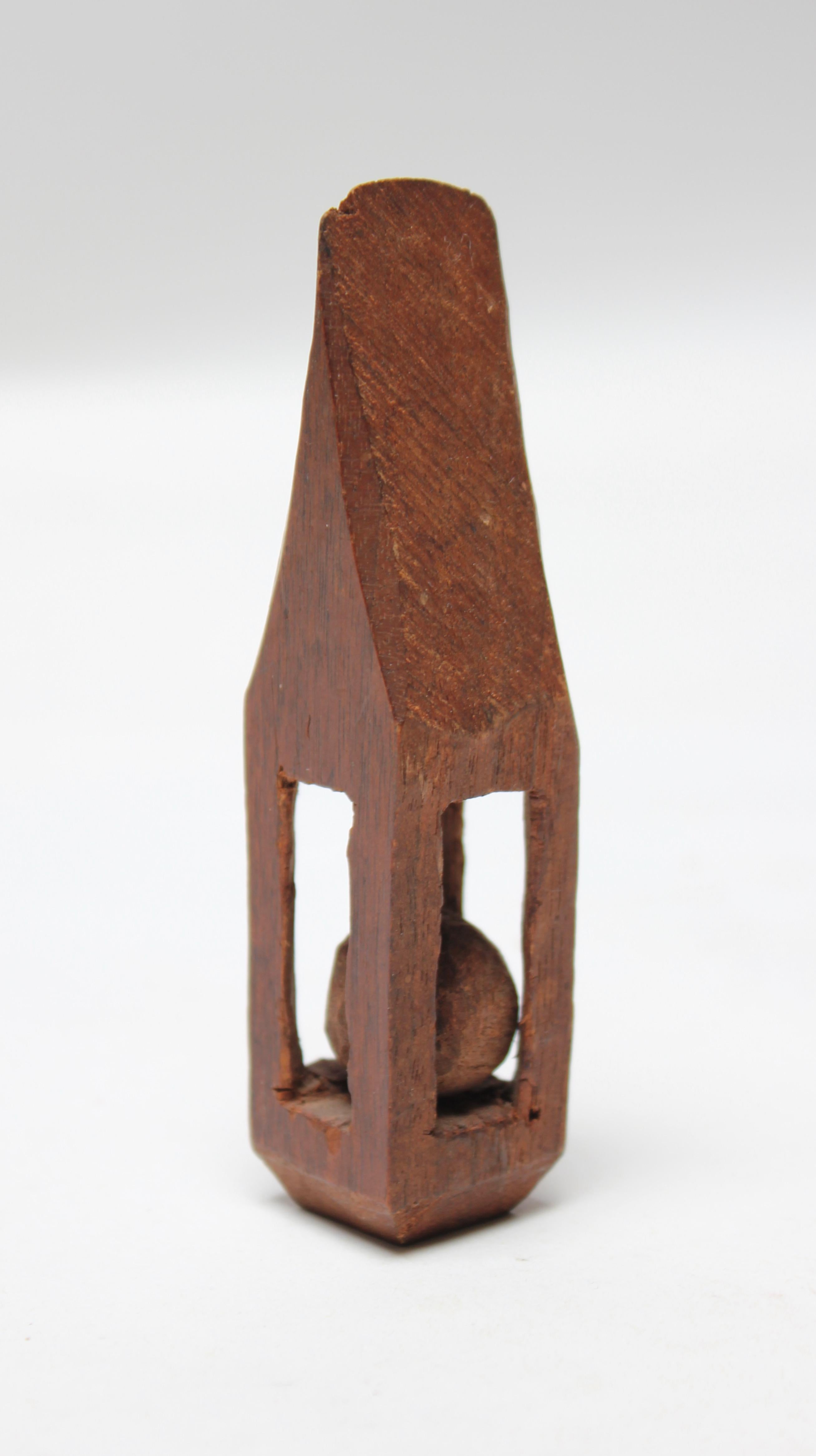 Figura de capricho de arte de trinchera de circa 1910 compuesta por una bola en una jaula, todo tallado en una sola pieza de madera. Las figurillas, como este ejemplo, fueron esculpidas por soldados durante la guerra. Presenta un buen envejecimiento