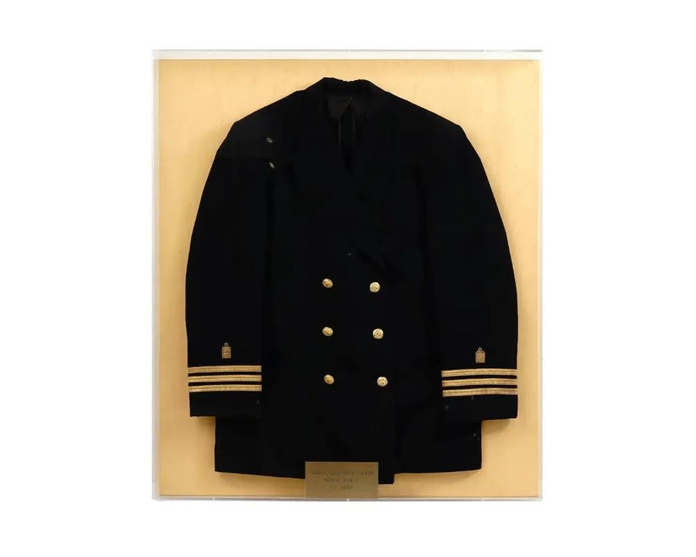 A WWII era US Army Jewish Military Uniform Chaplains jacket or coat. The military jacket is adorned with gold tone buttons and trim on sleeves, decorated with Jewish insignias, the embroidered Star of David. Presented in a shadow box with a gold