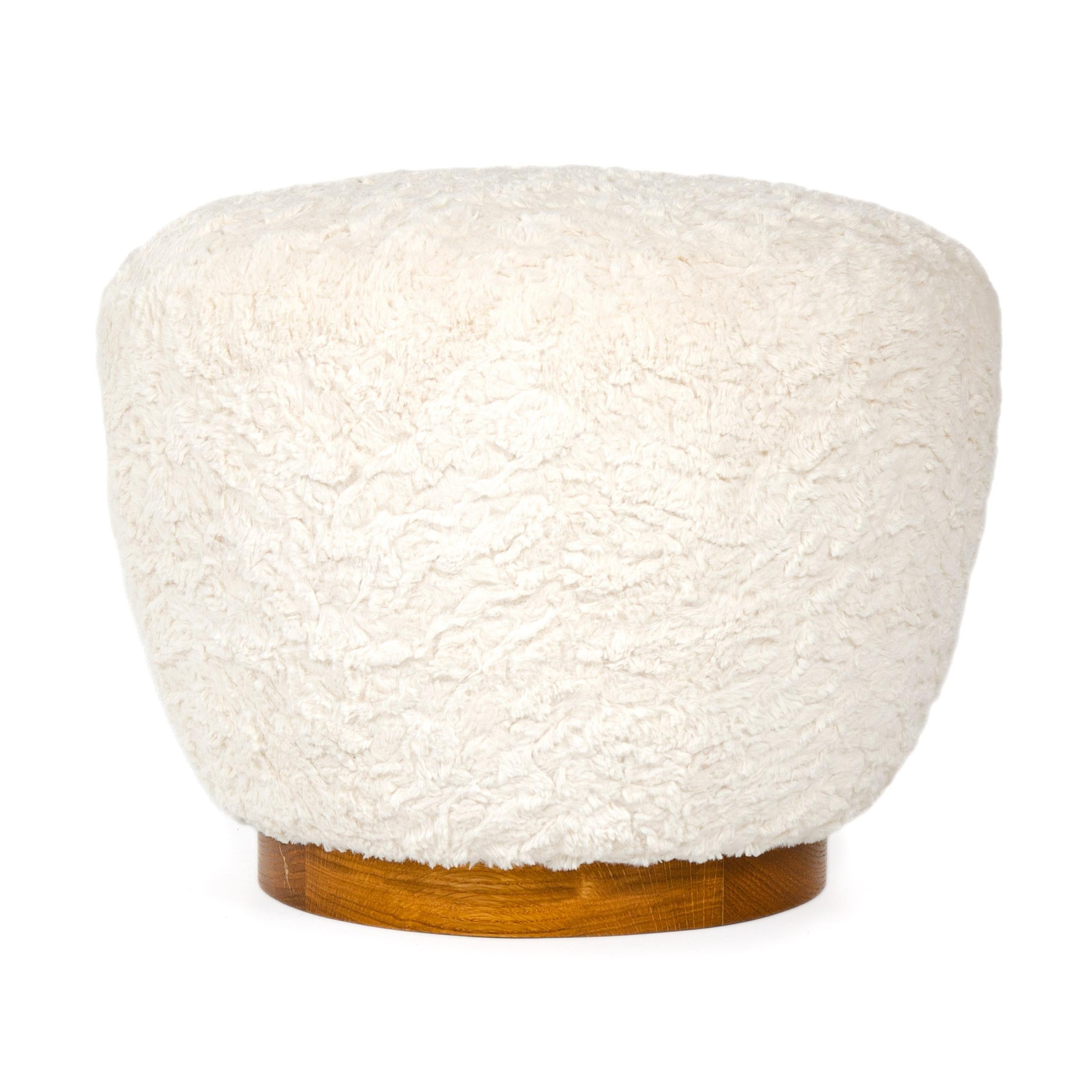 A traditional handcrafted and tied coil spring pouf ottoman with an oiled walnut base in white bouclé fabric.