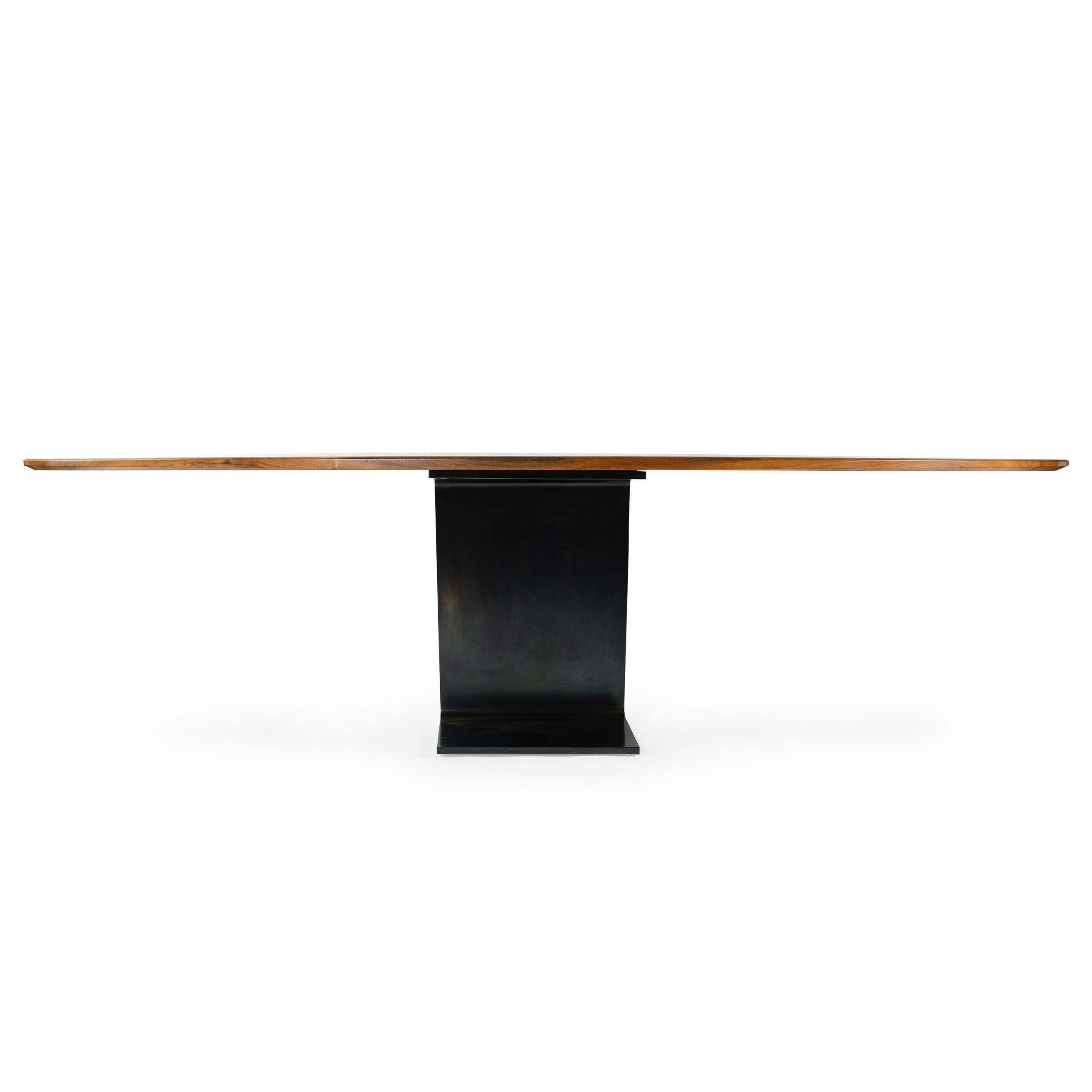A custom ellipse table with a solid walnut wood top and patinated steel base. Wood top measures 53.75 x 108 inches. Manufactured in NY by the Wyeth Workshop. Available in custom sizes.