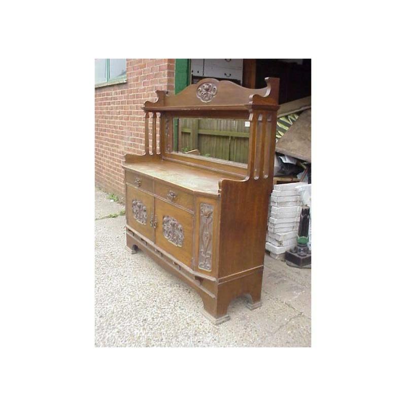 Credenza in rovere di buona qualità in stile Art & Lochhead con intagli floreali nitidi e stilizzati sulla parte superiore, sui lati e sulle ante dell'armadio, specchio oblungo centrale con 2 cassetti sottostanti e spazio per l'armadio che si apre