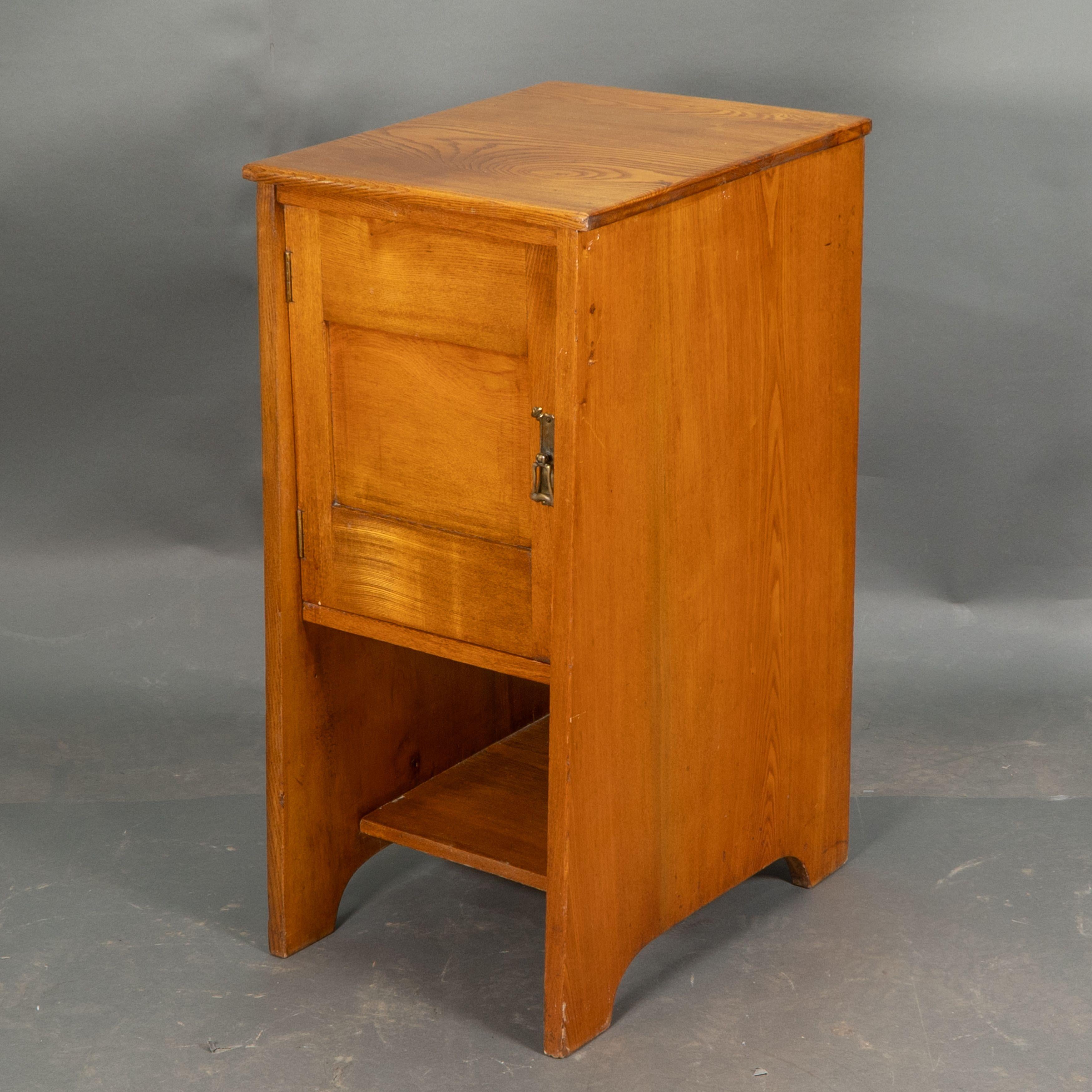 Wylie and Lochhead. A pair of Arts and Crafts Ash bedside cabinets with wonderful grain to the tops, a cupboard with stylised copper handles, and an open shelf below.