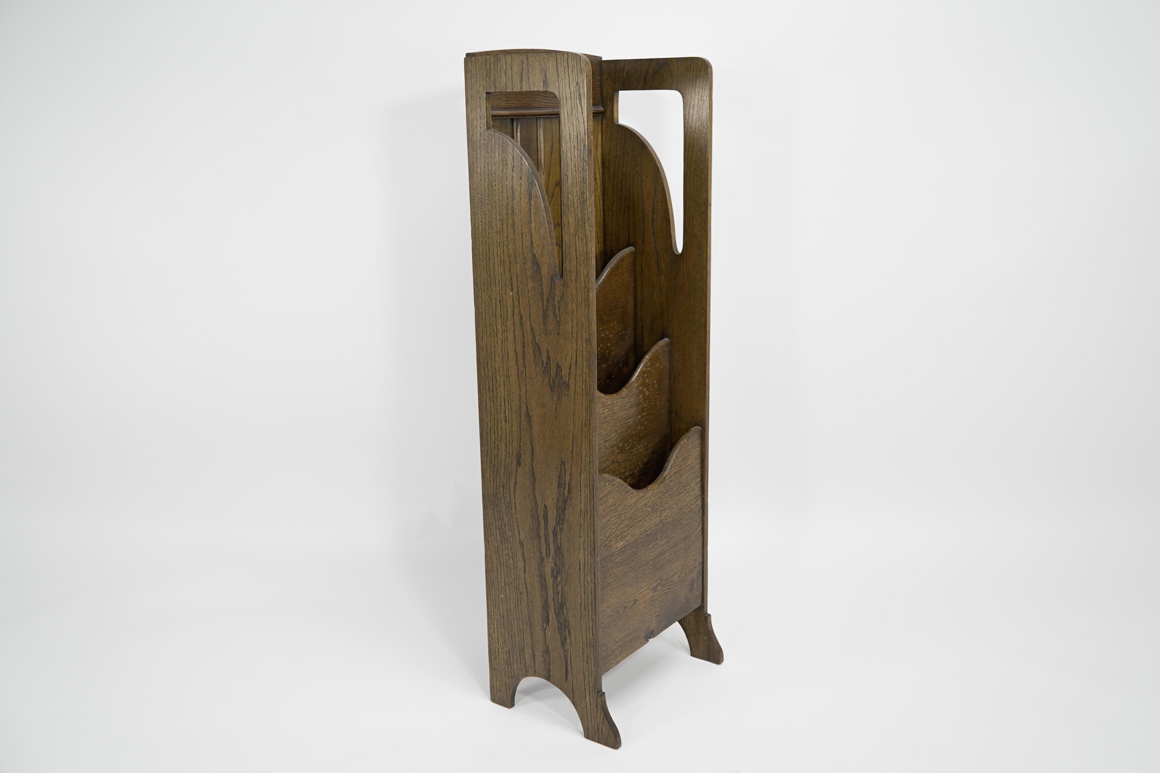 Wylie and Lochhead attributed. A Glasgow Style Arts and Crafts oak magazine or paper rack with waterfall style compartments and stylized cut-outs to the top.