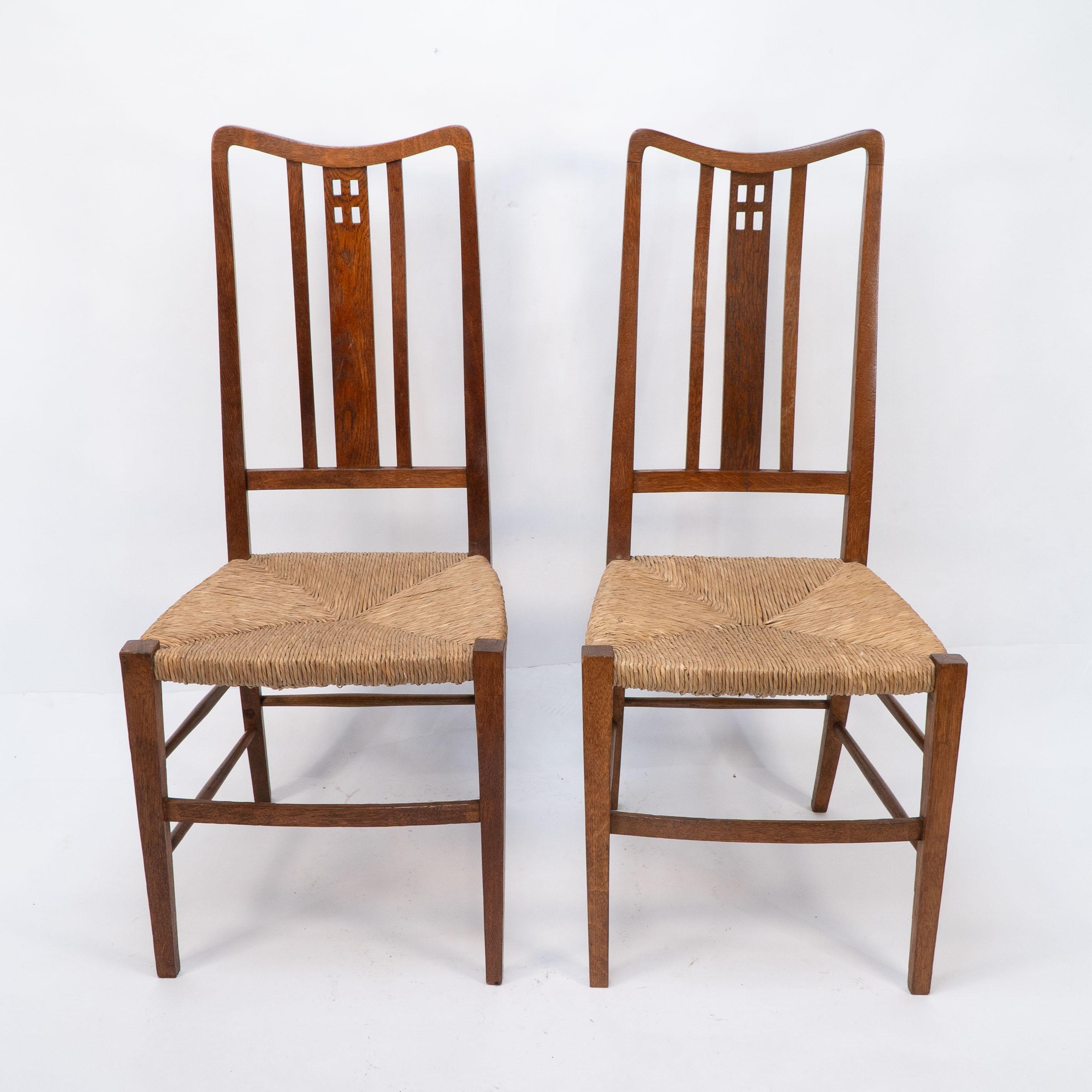 Wylie et Lochhead attribués. Paire de chaises d'appoint ou de chambre à coucher en jonc avec quatre découpes carrées sur le haut du dossier en forme. Les deux chaises ont été restaurées par des professionnels et récemment repoussées.