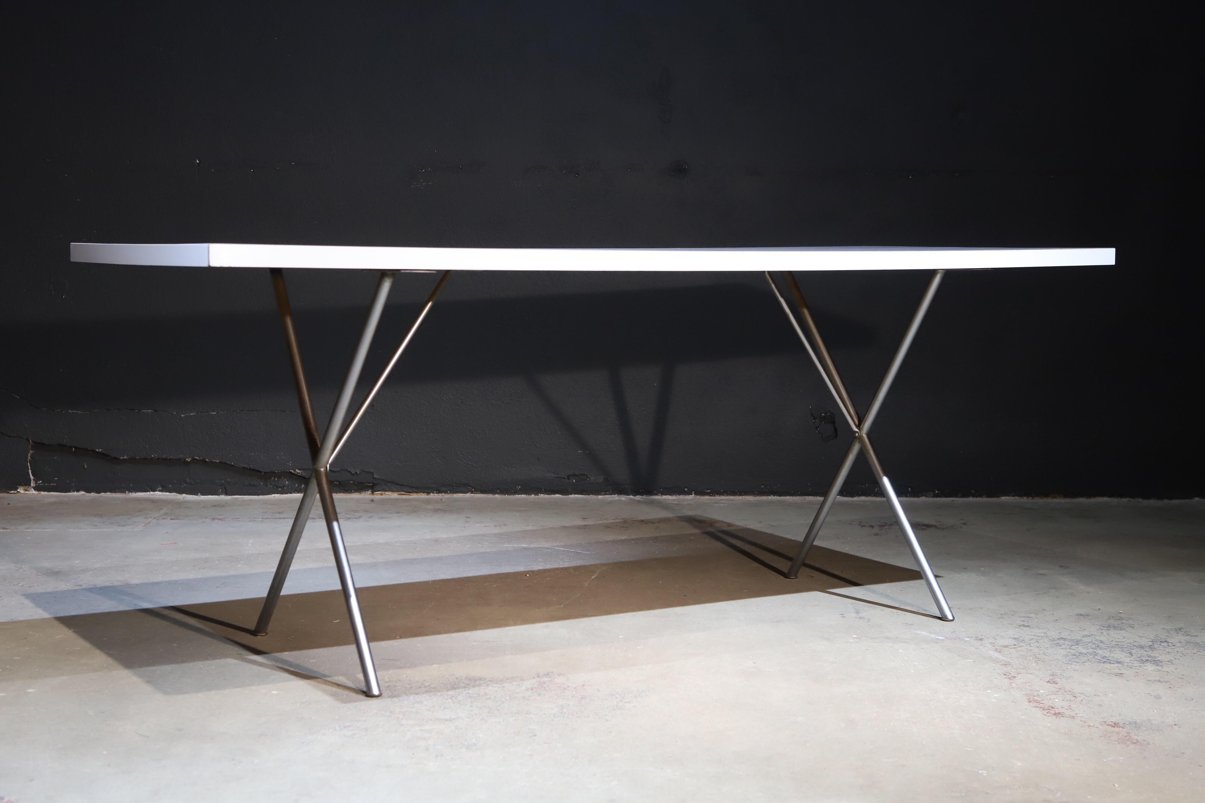 Simplistic design at its finest. 

Early X-base dining table with white Formica style top. 

Designed by George Nelson for Herman Miller.

Photographed with John Keal iron chairs and Artemide Spyros for scale.